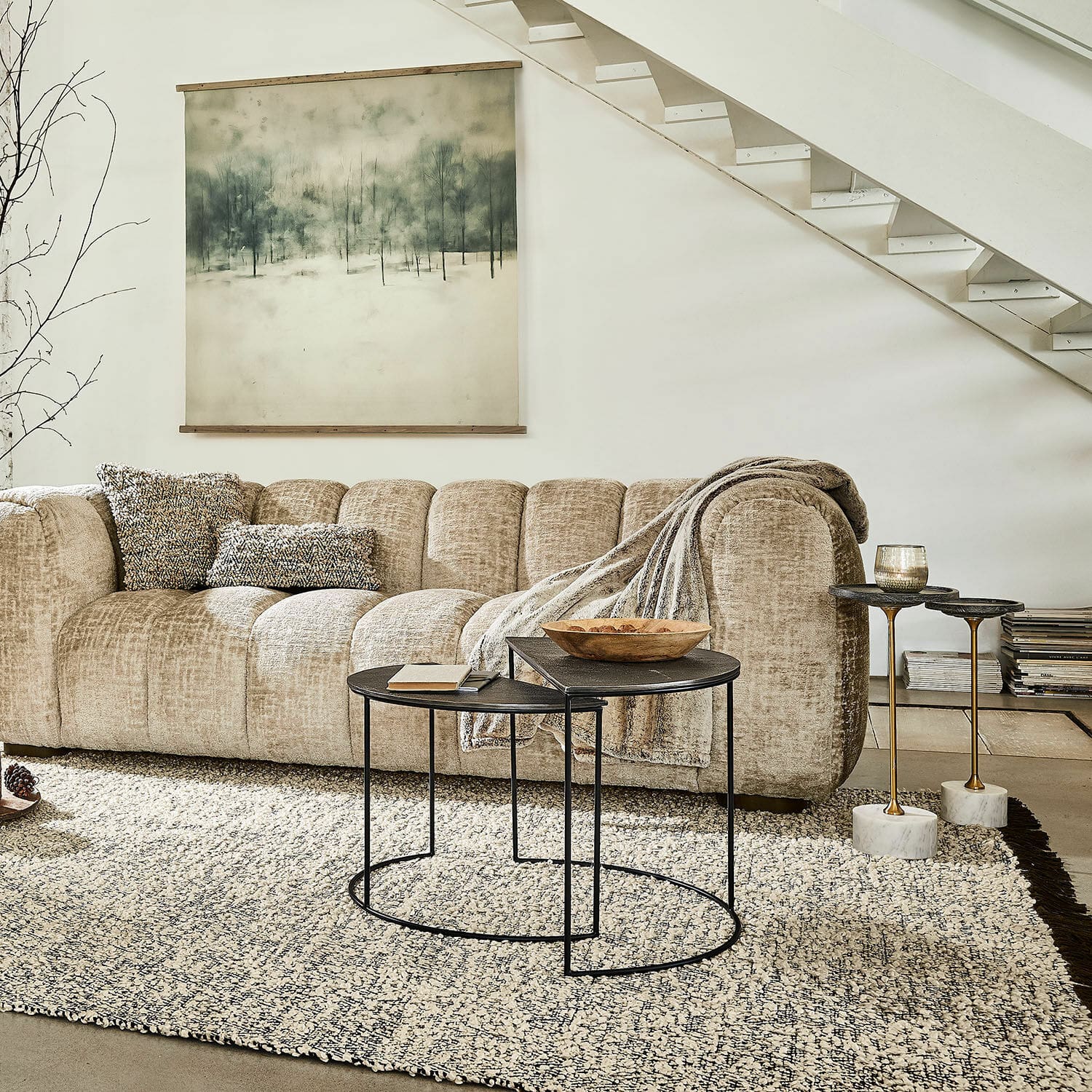 Beige Sofa aus weichem Stoff mit Kissen und schwarzen Metall-Couchtischen im Wohnzimmer