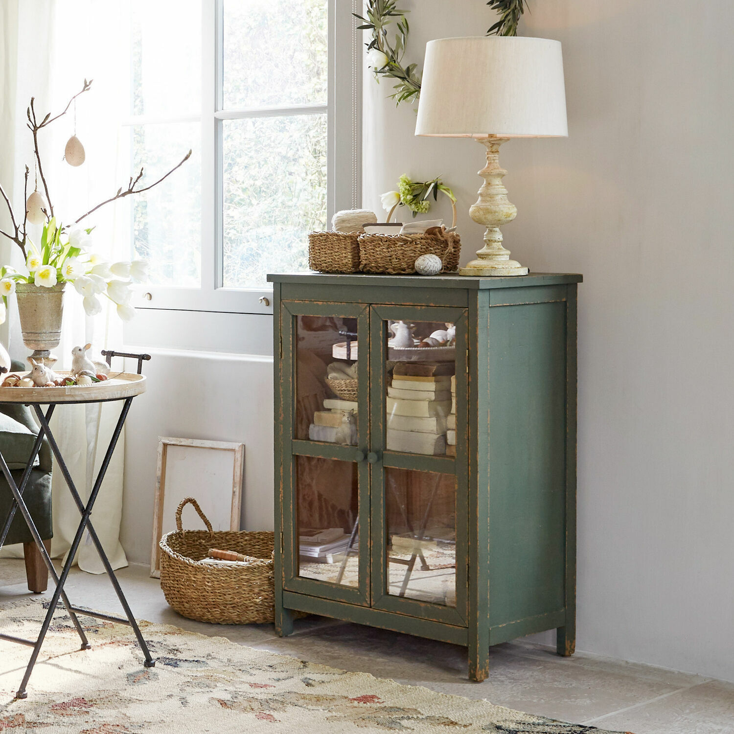 Grüner Holzschrank mit Glastüren im Vintage-Stil in hellem Wohnzimmer