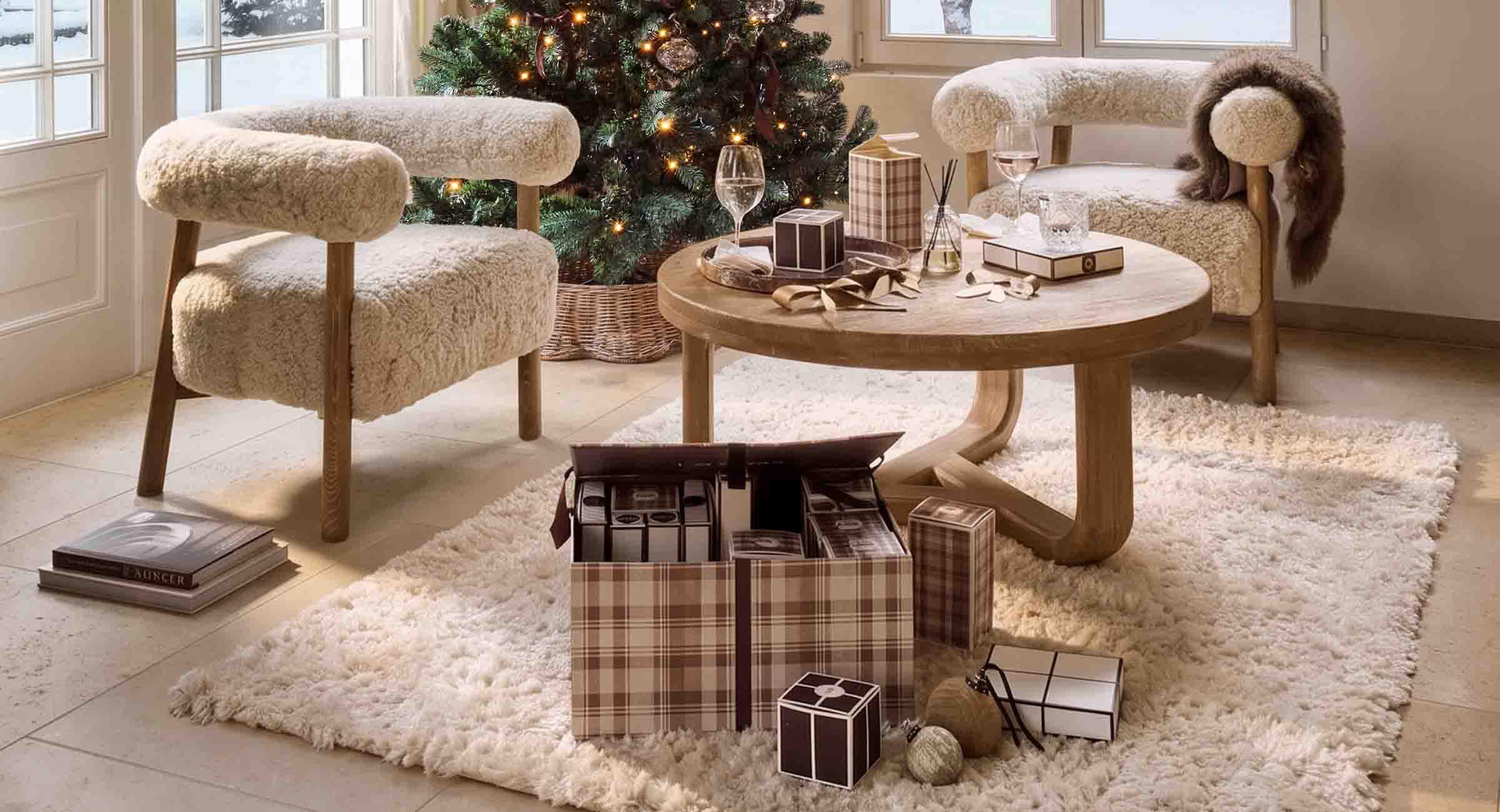 Gemütliches Wohnzimmer mit cremefarbenen Fellstühlen und Holztisch neben festlich geschmücktem Weihnachtsbaum