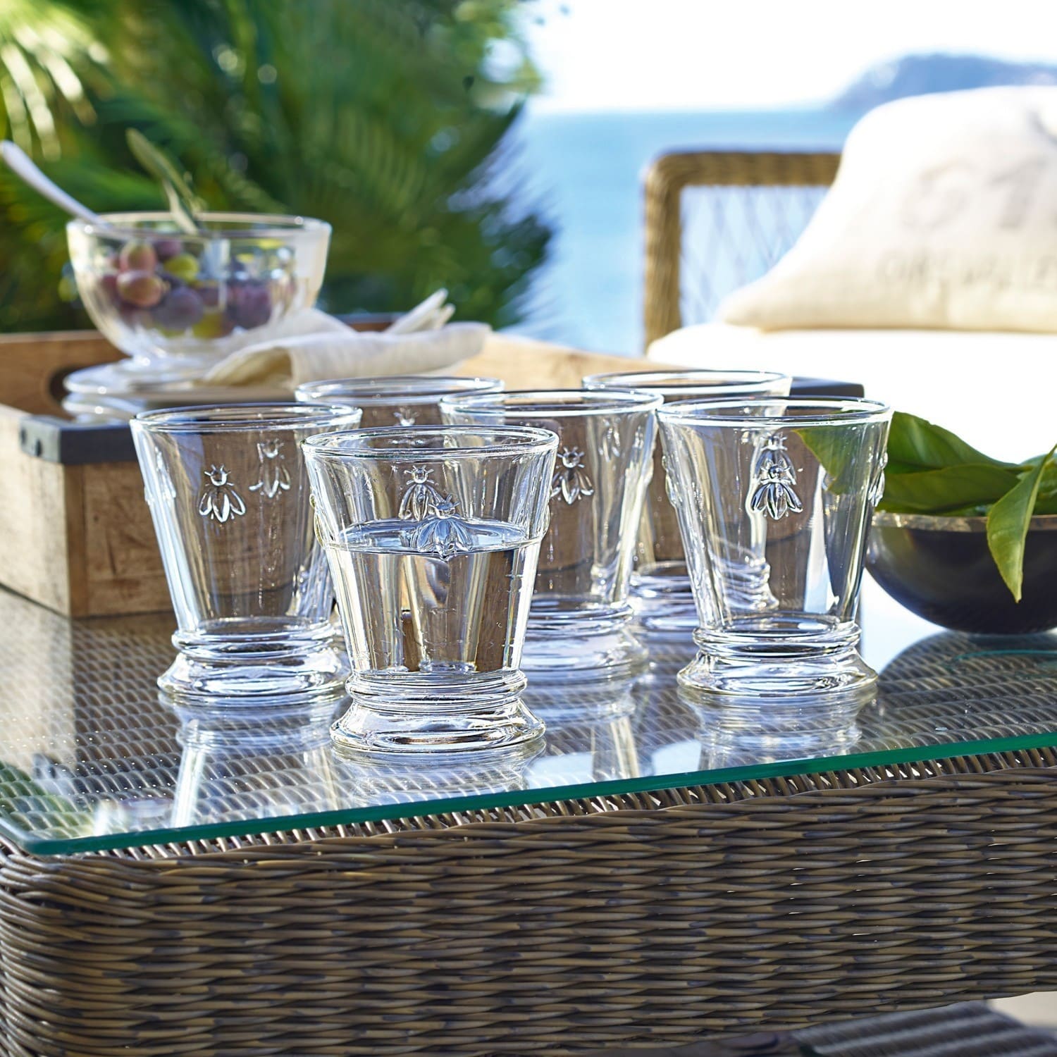 Wassergläser 6er Set Abeille Sechsteiliges Set aus klarem Glas mit Bienenmotiv auf Glastisch im Außenbereich