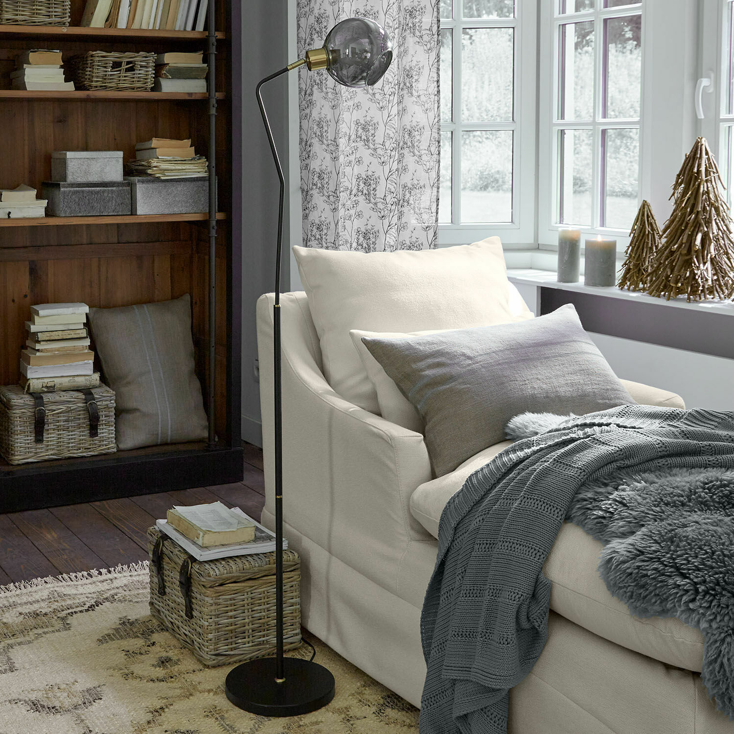 Stehlampe aus schwarzem Metall mit Glaskugel im modernen Wohnzimmer mit beigem Sofa