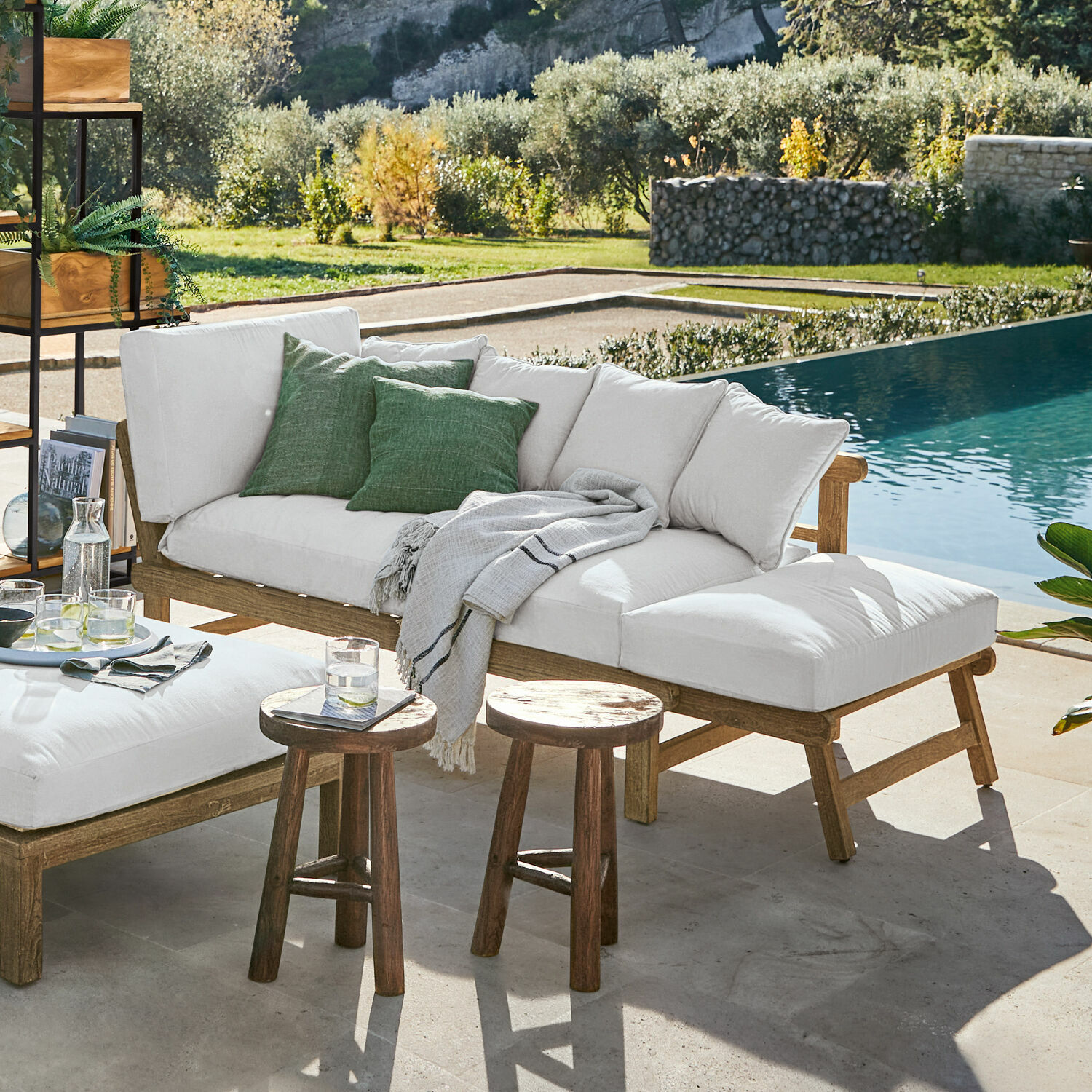 Outdoor-Möbelset aus Holz mit cremefarbenen Polstern und grünen Kissen neben dem Pool