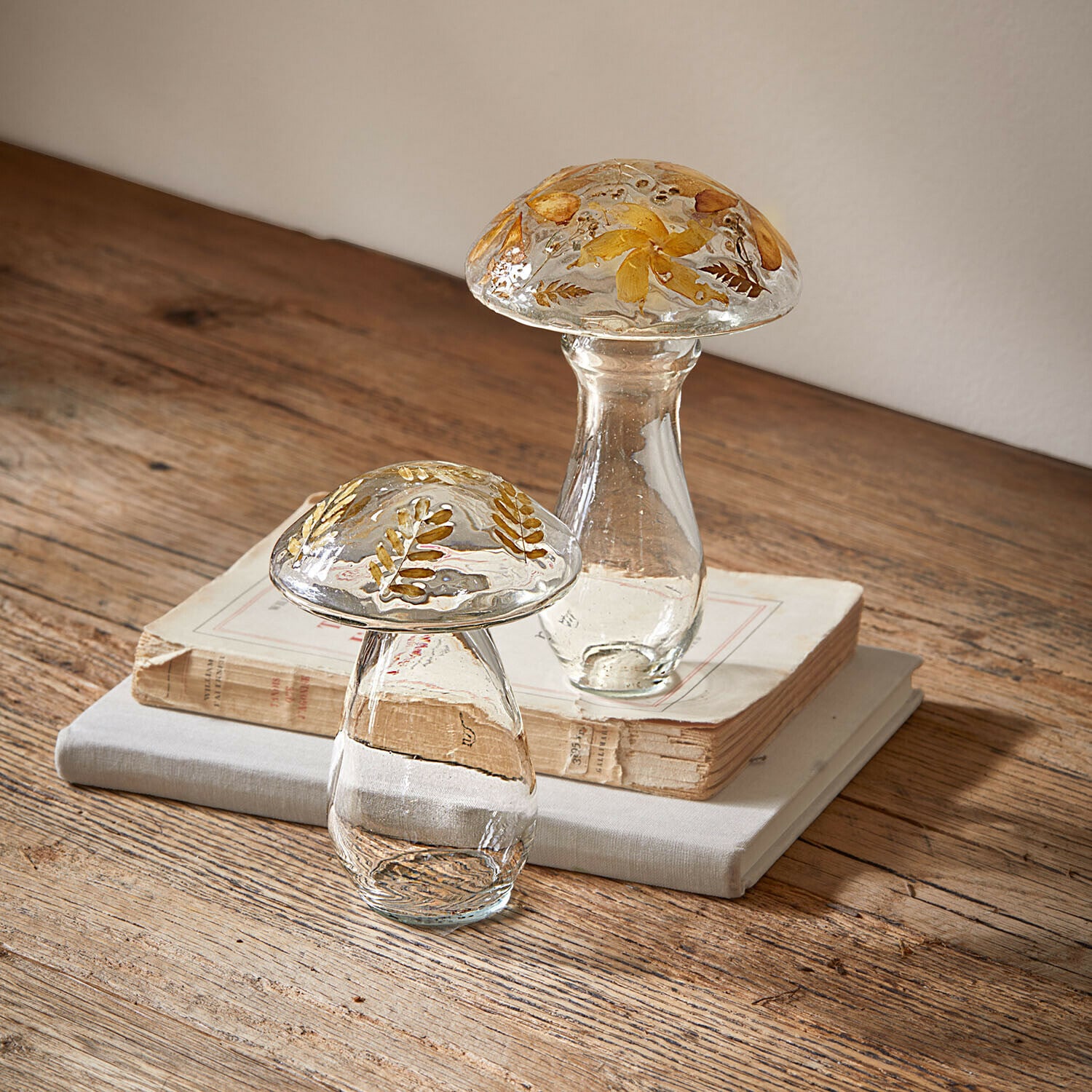 Deko-Pilz 2er Set Émurise Glasdekorationen in Pilzform mit getrockneten gelben Blumen auf Holztisch