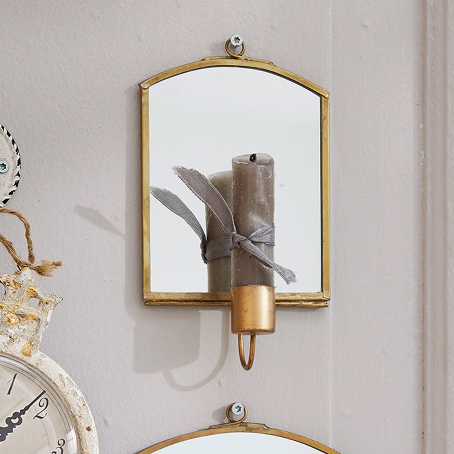 Wandspiegel mit Messingrahmen und grauer Kerze im Halter, Vintage-Dekoration für Zuhause
