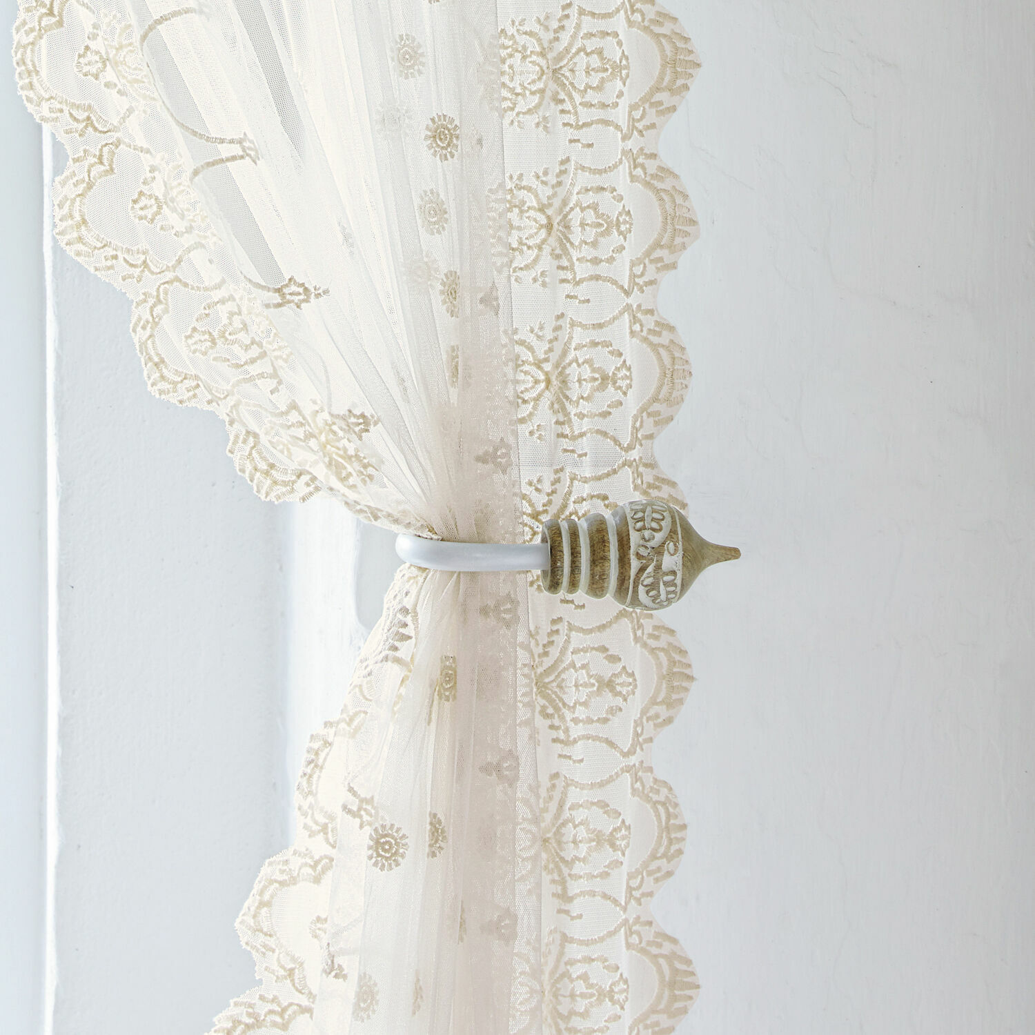 Vorhanghalter 2er Set Talon Beige Spitzenvorhang mit dekorativem Metallhalter vor hellem Wandhintergrund, Fensterdekoration