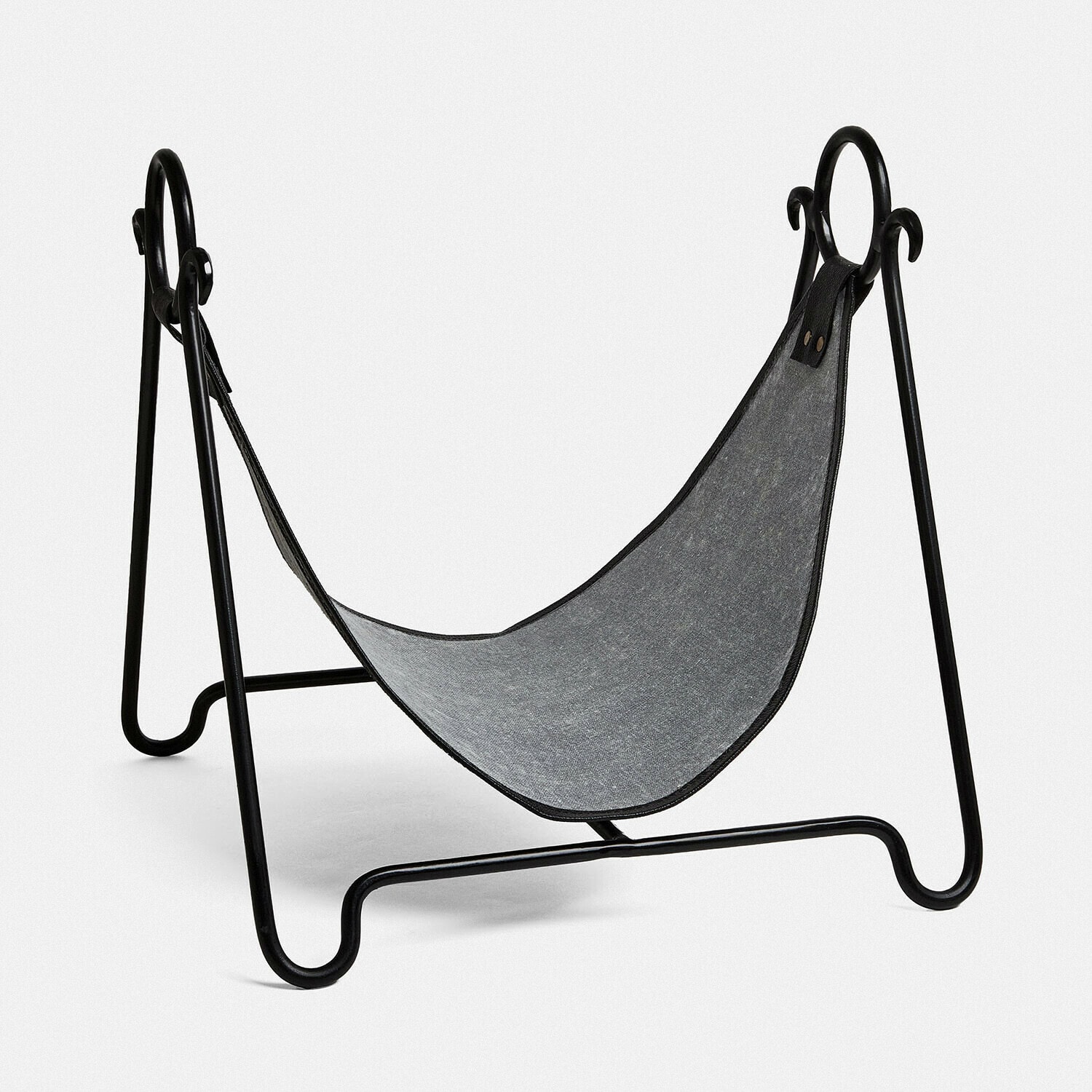 Schwarzer Metall-Holzständer mit grauem Stoff zum Lagern von Kaminholz im Wohnbereich