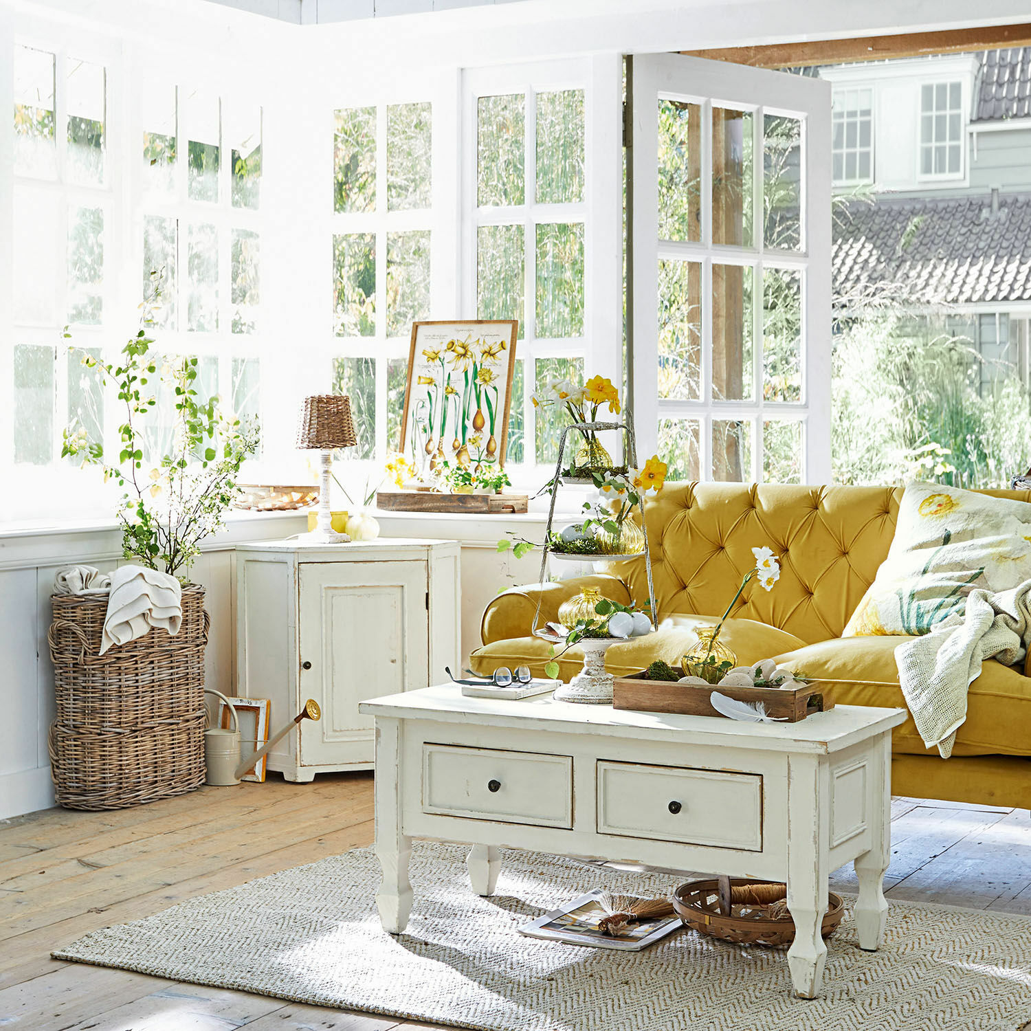 Gemütliches Wohnzimmer mit gelbem Samtsofa und weißem Holzcouchtisch im Vintage-Stil