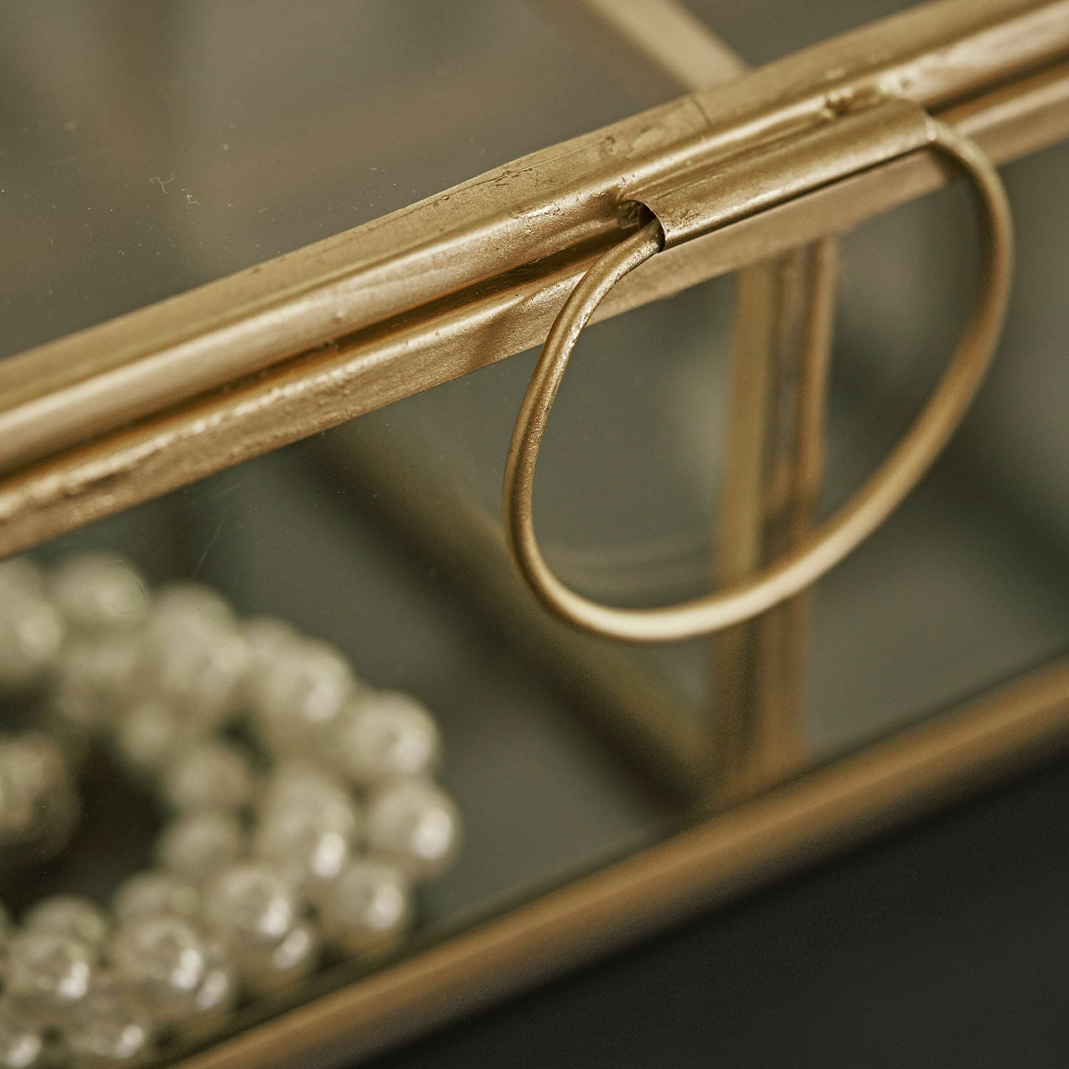 Goldfarbene Metallschatulle mit Ringgriff und Spiegelboden zur Schmuckaufbewahrung