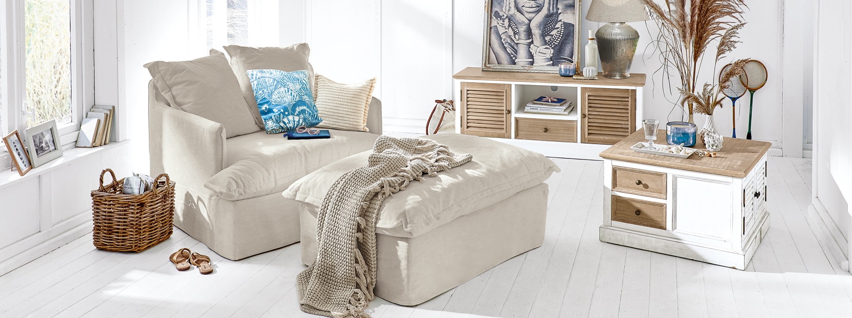 Beiger Ecksofa mit Hocker und Holzmöbeln in hellem, maritimem Wohnstil