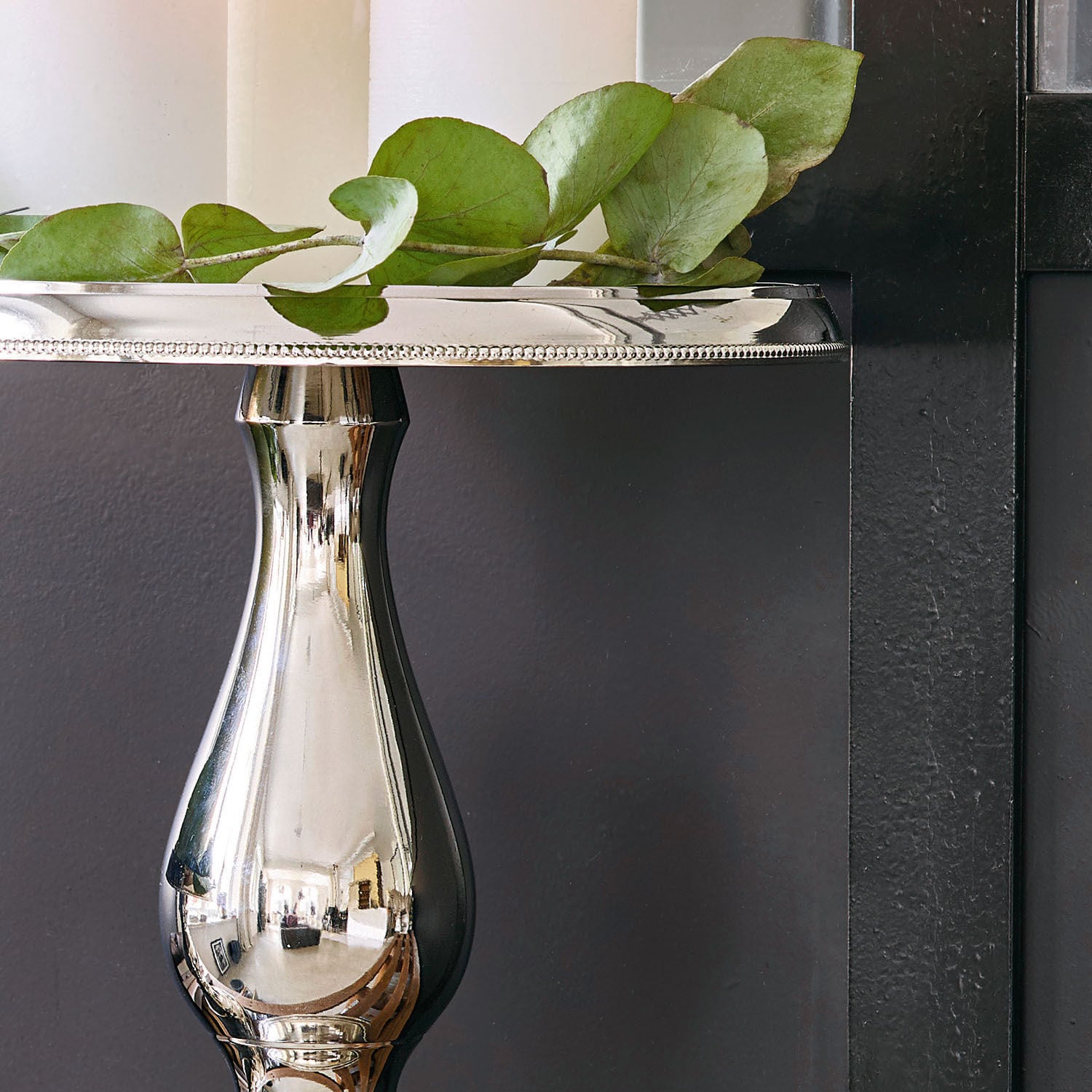 Silberne Metall-Etagere auf Fuß mit grünen Blättern, elegante Tischdekoration