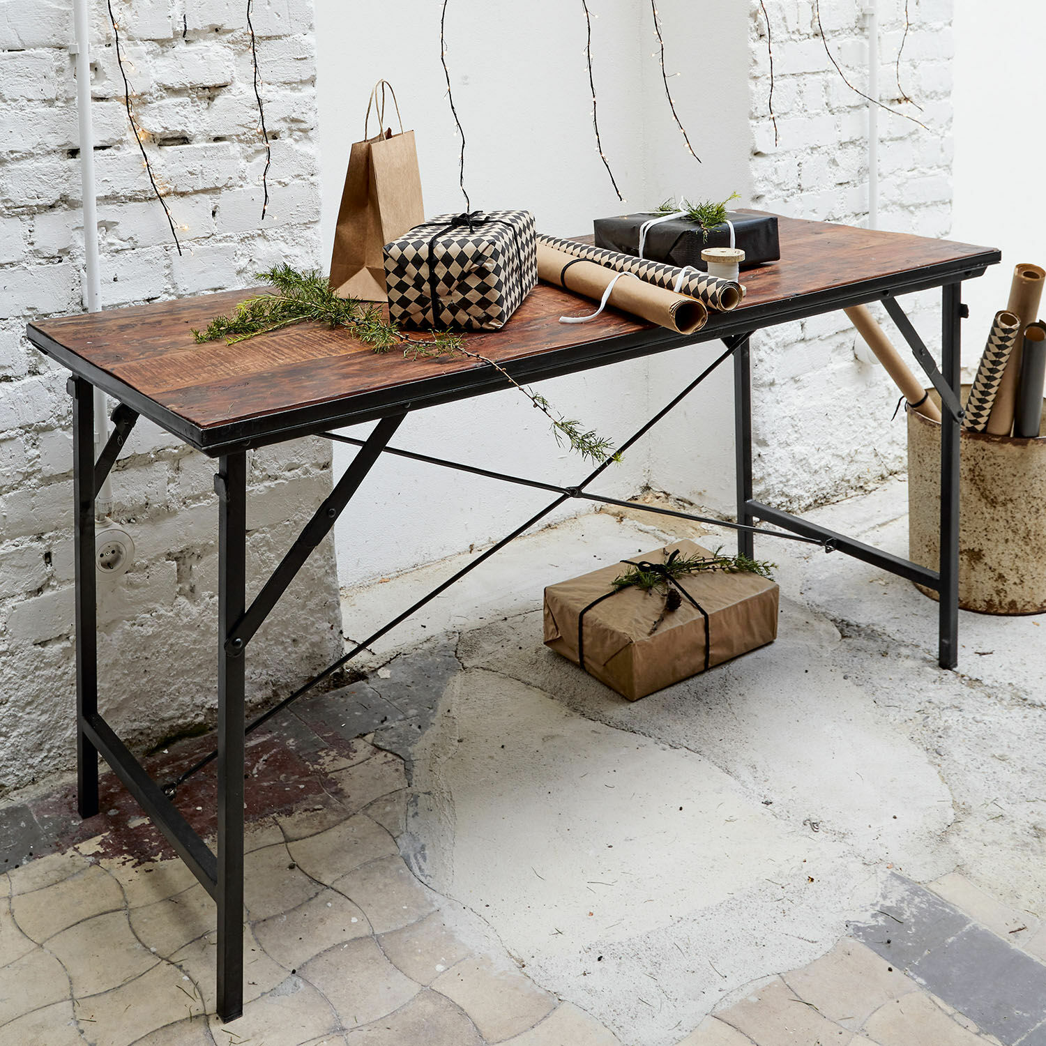 Tisch aus dunklem Holz mit Metallbeinen, dekoriert mit Geschenken und Vintage-Geschenkpapier