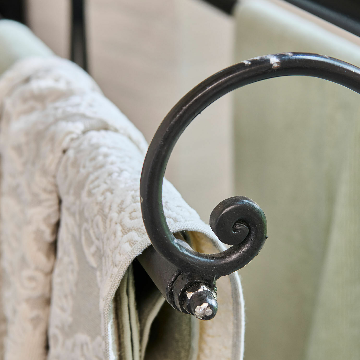 Schwarzer Metall-Handtuchhalter mit dekorativer Spirale und cremefarbenem gemustertem Handtuch, Badaccessoire