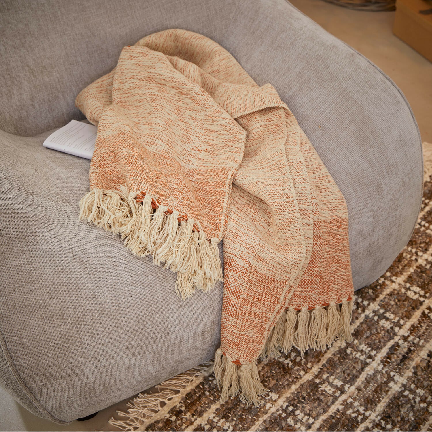 Plaid Winlow Beige-orangefarbene Decke mit Fransen auf grauem Sessel, weiches Material für Wohnraumdeko