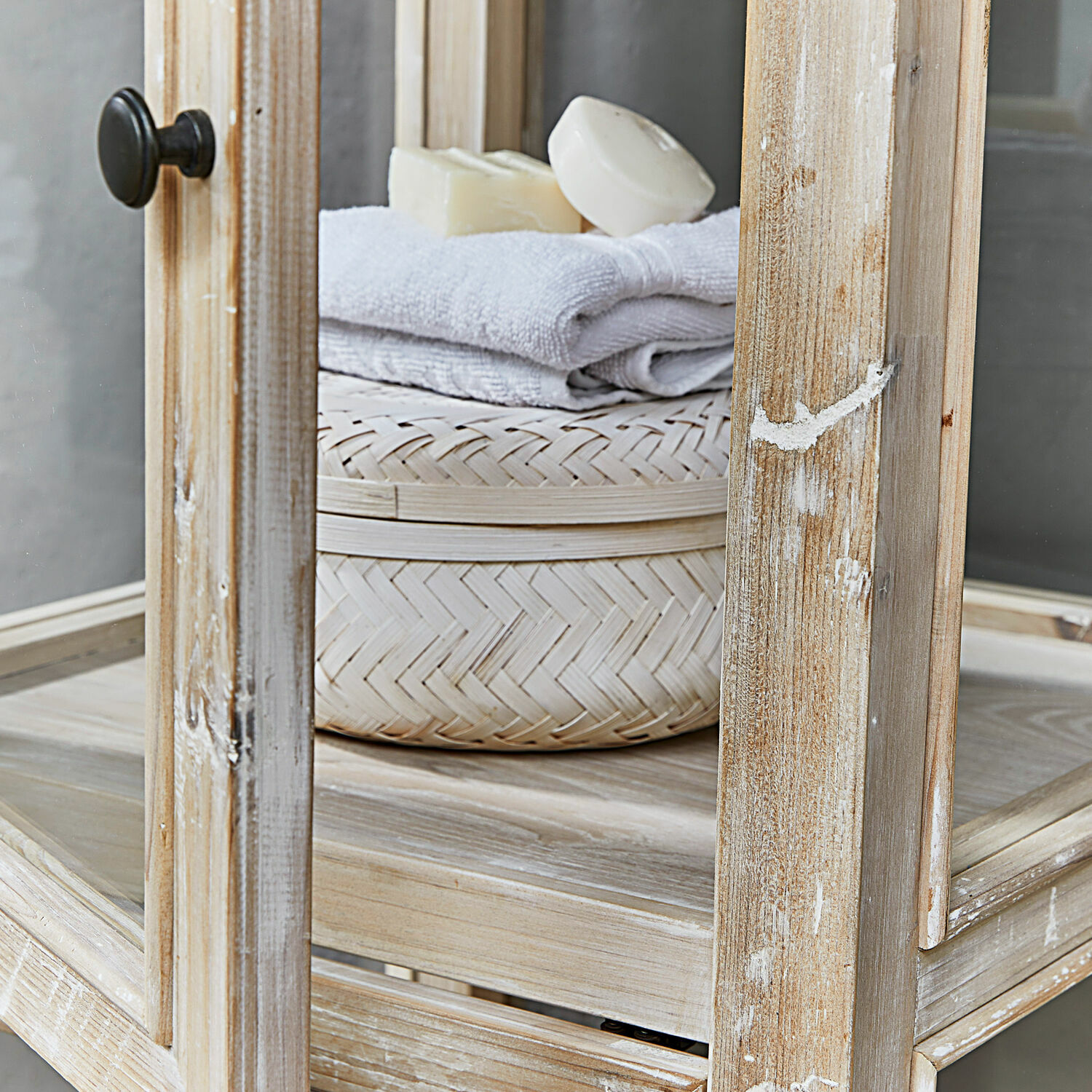 Natürliches helles Rattan-Aufbewahrungsbox mit Handtuch und Seife auf Holzregal