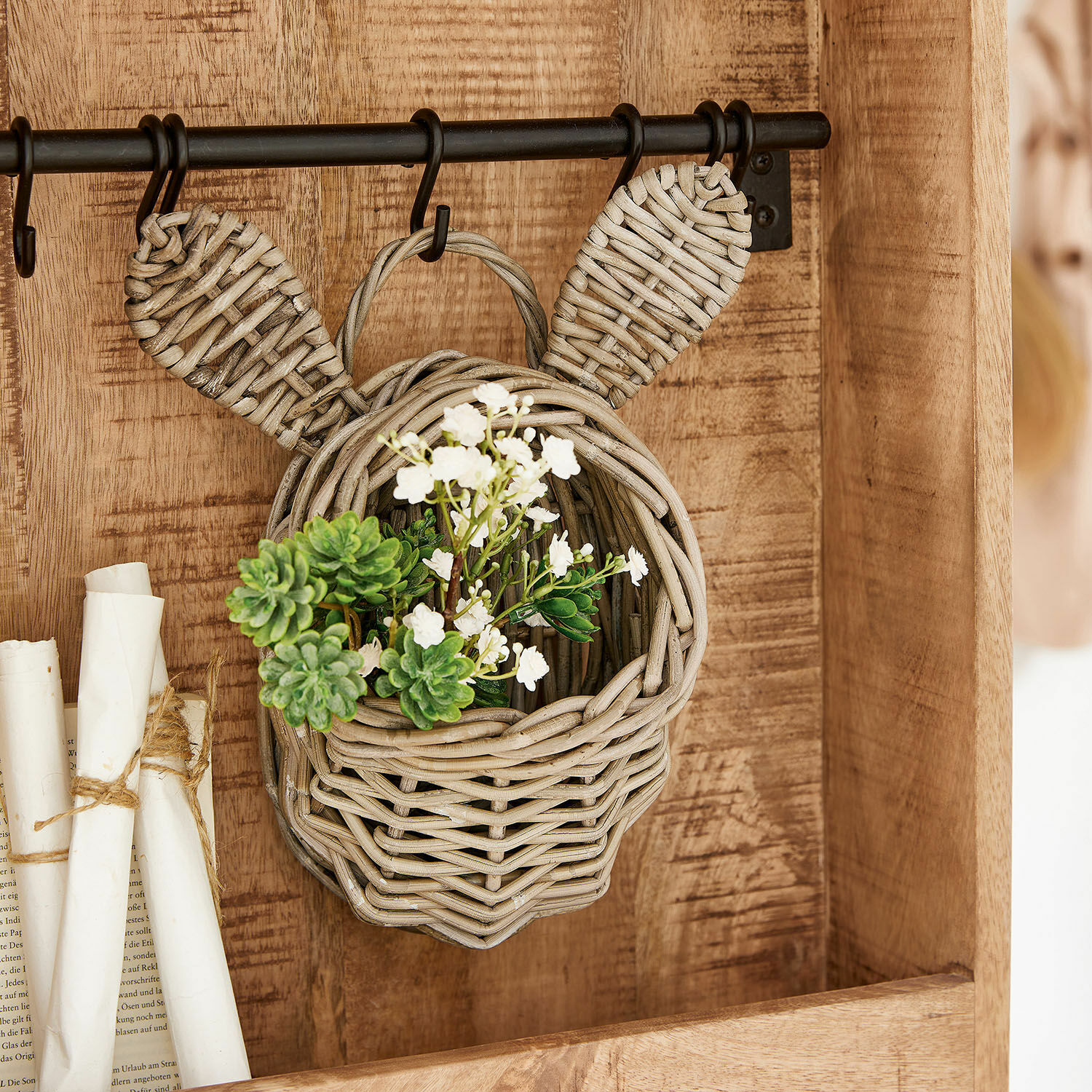 Korb Frances Hängender Korb aus Rattan in Kopf- und Ohrenform mit grünen und weißen Blumen dekoriert