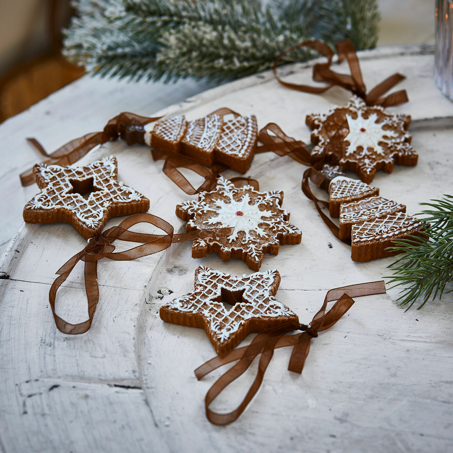 Anhänger 6er Set Chimayo Set Lebkuchen-Weihnachtsanhänger mit weißer Glasur und braunen Bändern auf Holztisch