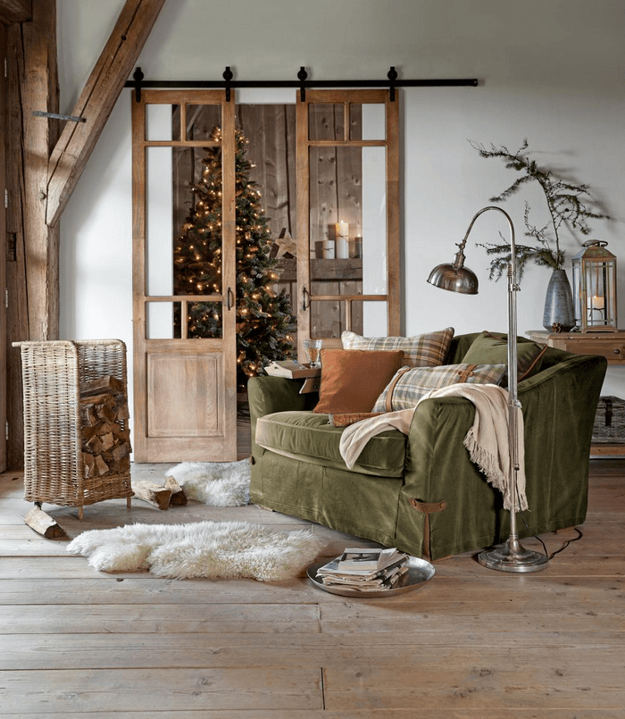 Grüner Stoffsessel in rustikalem Wohnzimmer mit Holzboden und Weihnachtsdekoration