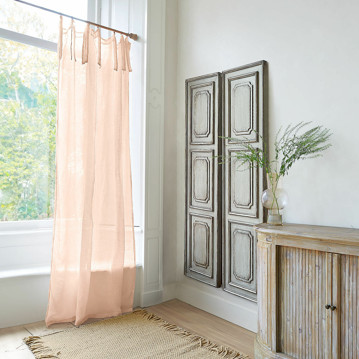 Transparenter Leinenvorhang in zartem Rosa in hellem Raum mit natürlichen Holzmöbeln