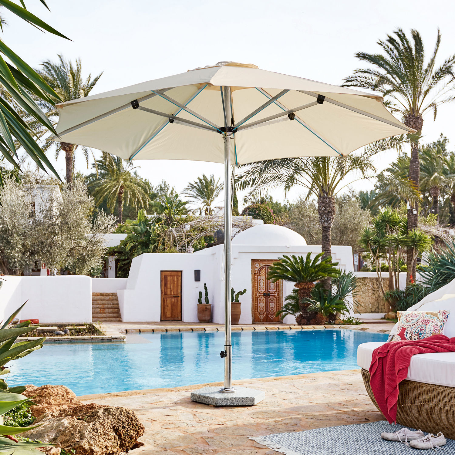 Beiger Gartenschirm mit Metallgestell am Pool, ideal zum Entspannen im Freien