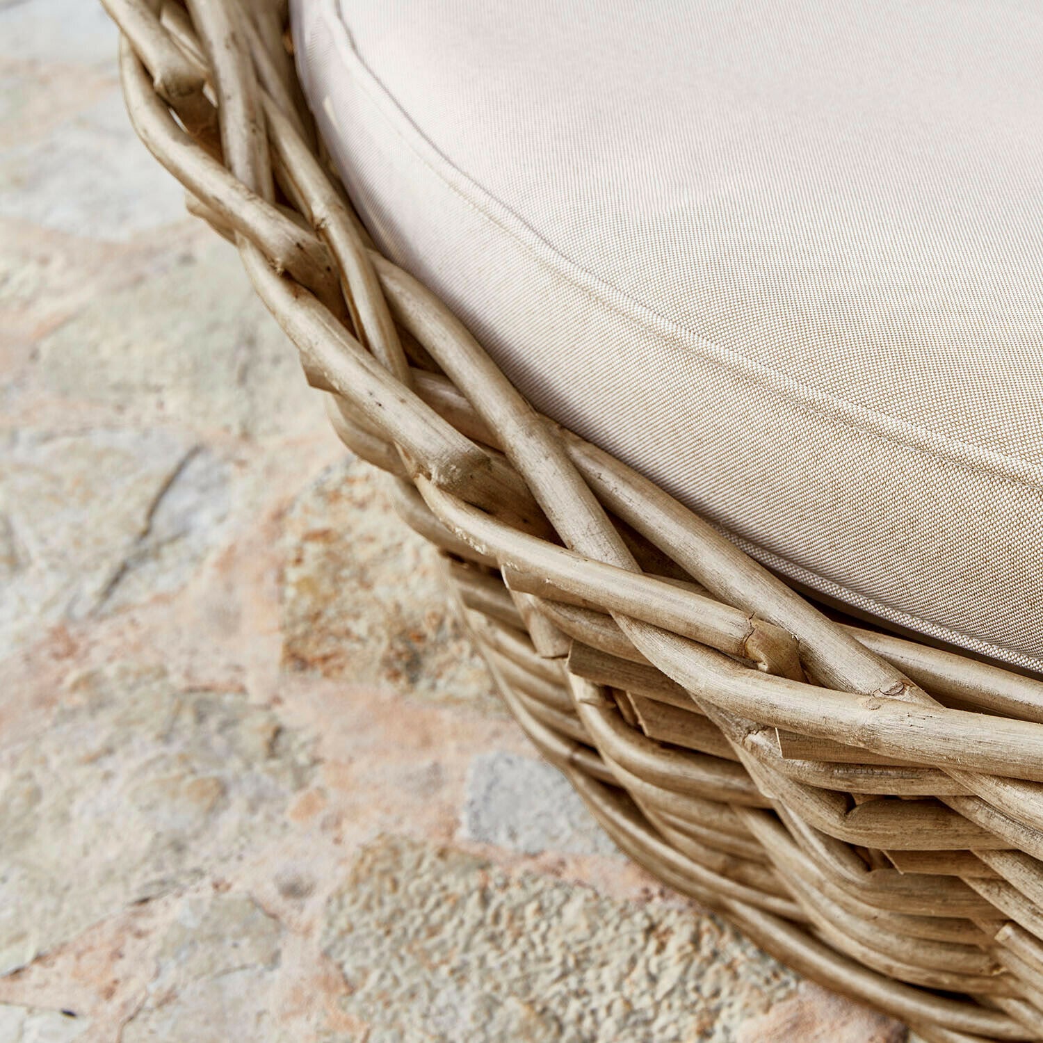 Runder Fußhocker aus Rattan mit beigem Polster, natürlicher Look für Wohn- und Gartenbereich