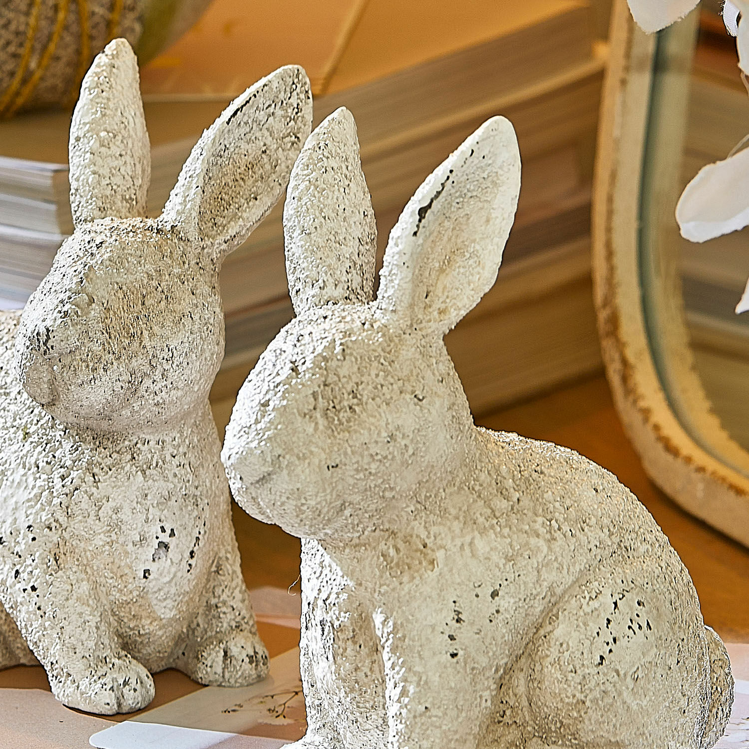 Weiße dekorative Hasenfiguren aus strukturiertem Material auf Holztisch als Wohnaccessoire