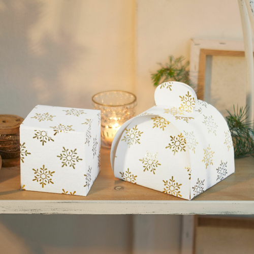 Weiße Geschenkboxen mit goldenen Schneeflocken auf Holzregal, festliche Weihnachtsdekoration