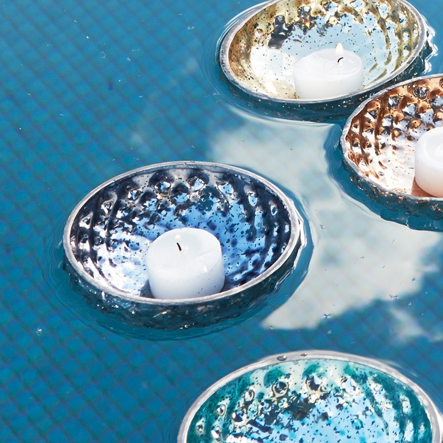 Bunte schwimmende Metall-Kerzenhalter auf Wasser, dekorative Wohn- und Gartendeko