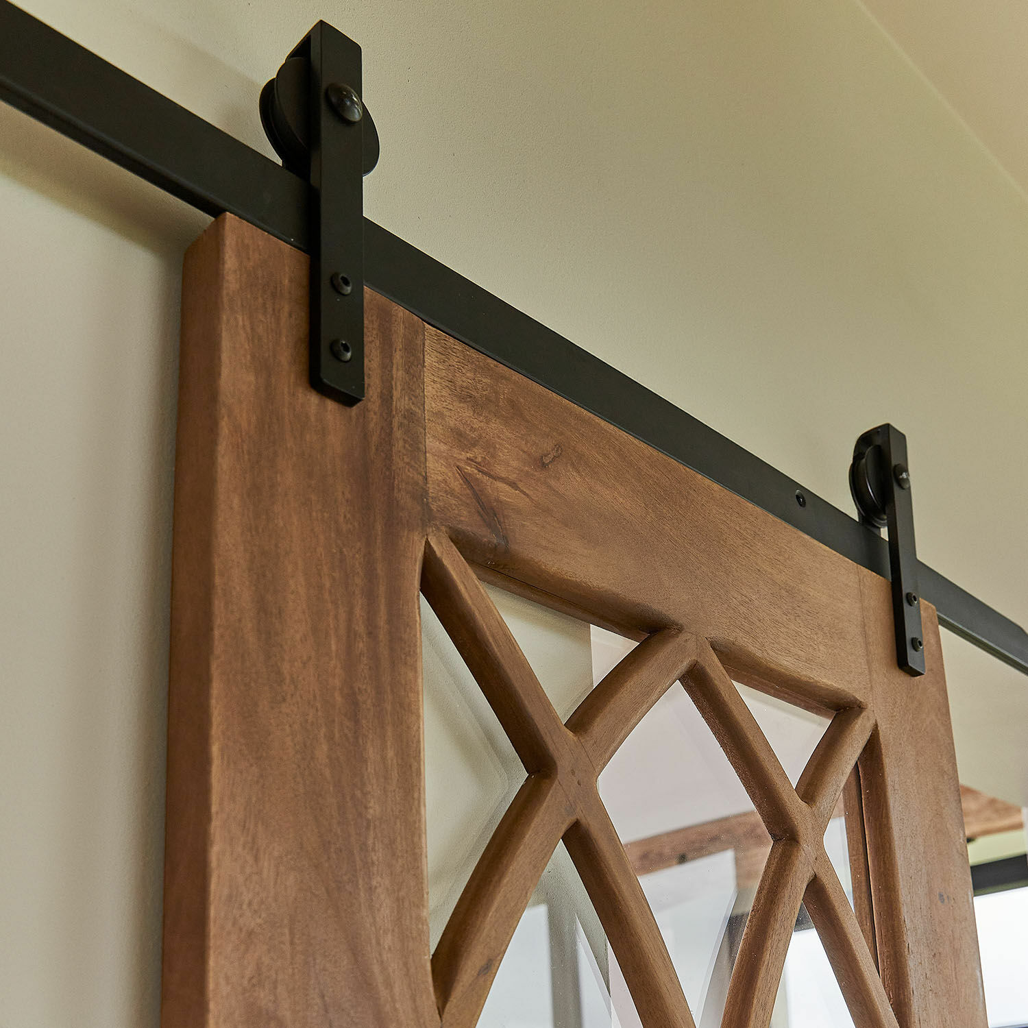 Holz-Schiebetür mit dekorativem Muster und schwarzer Metallaufhängung für modernes Interieur