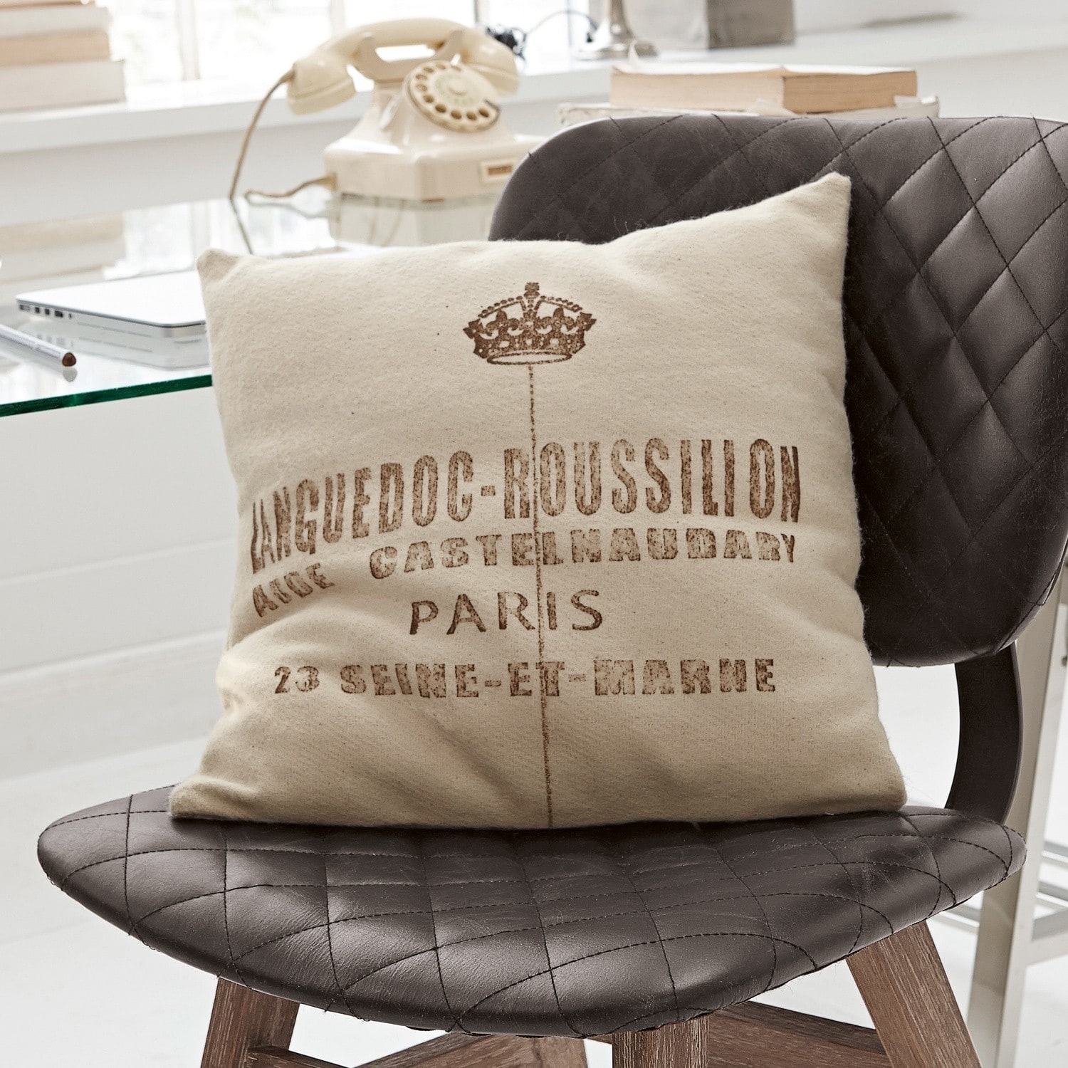 Kissen Roussilion Beiges Dekokissen mit Languedoc-Roussillon Aufdruck auf schwarzem, gestepptem Lederstuhl