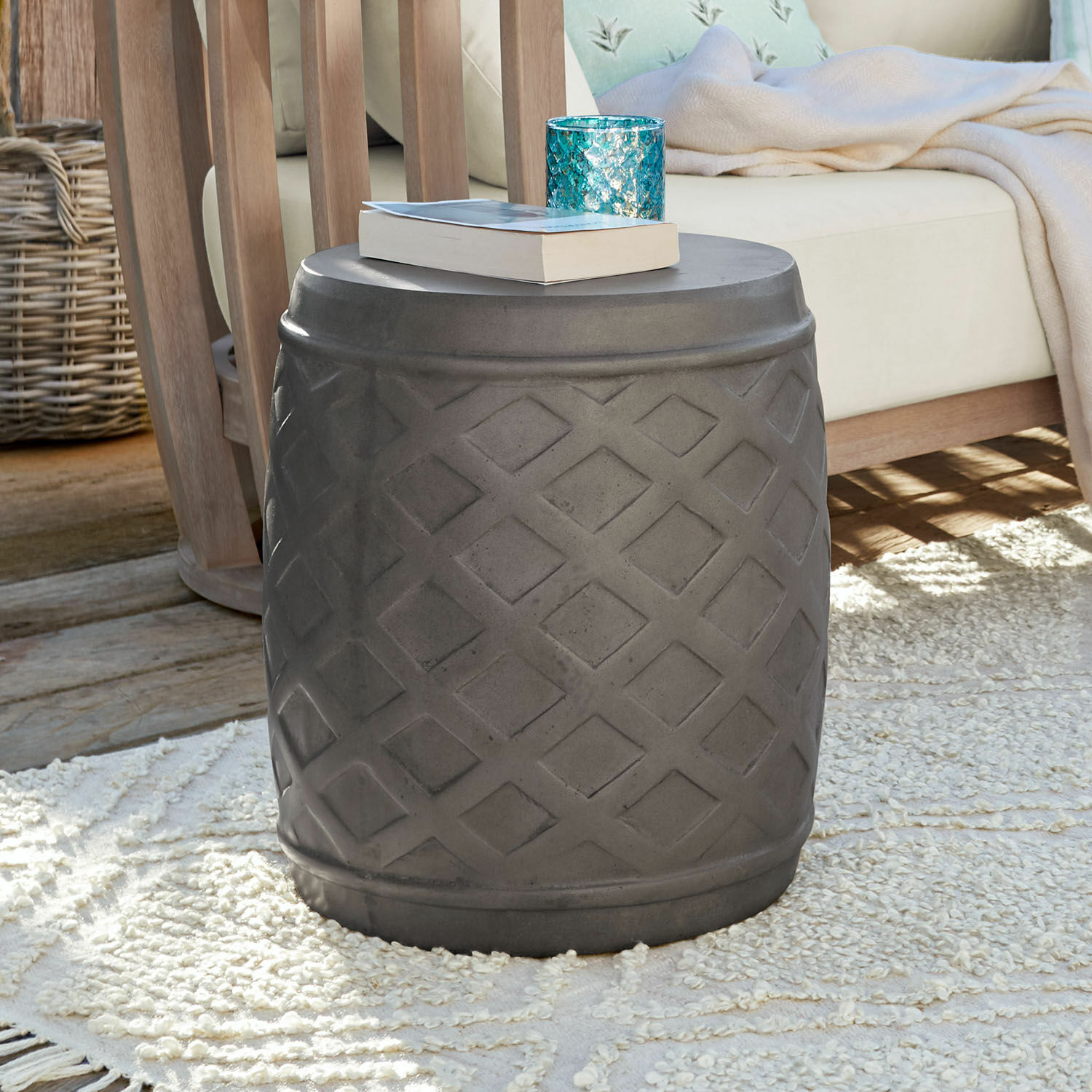 Hocker Plévin Grauer Beistelltisch aus Beton mit geometrischem Muster auf Teppich im Wohnzimmer mit Holzmöbeln
