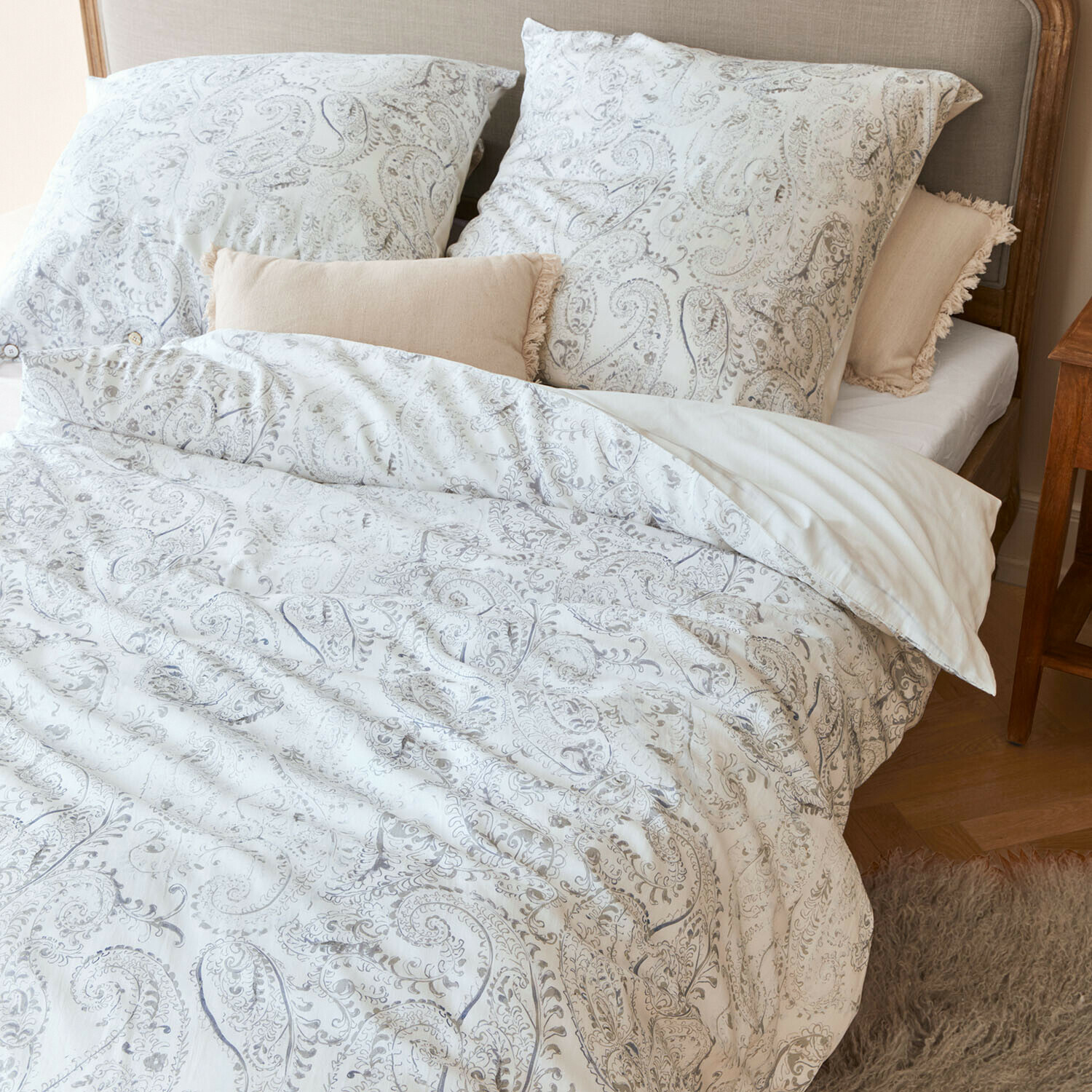 Bettwäsche Caselia Baumwoll-Bettwäsche mit hellem Paisley-Muster auf Bett mit beigen Dekokissen