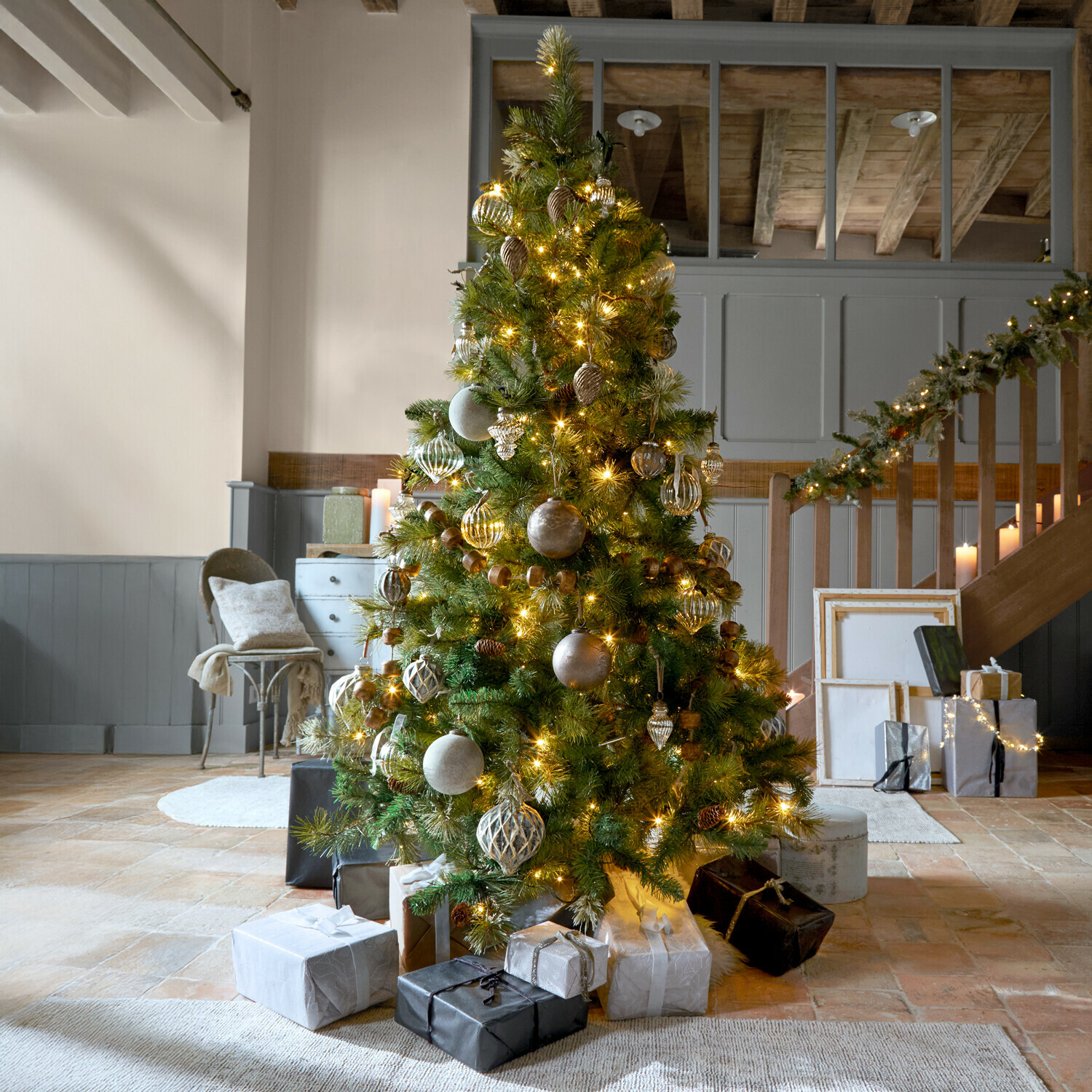 Weihnachtsbaum Aure Weihnachtsbaum mit grünen Zweigen und goldenen Lichtern geschmückt in gemütlichem Raum mit Geschenken