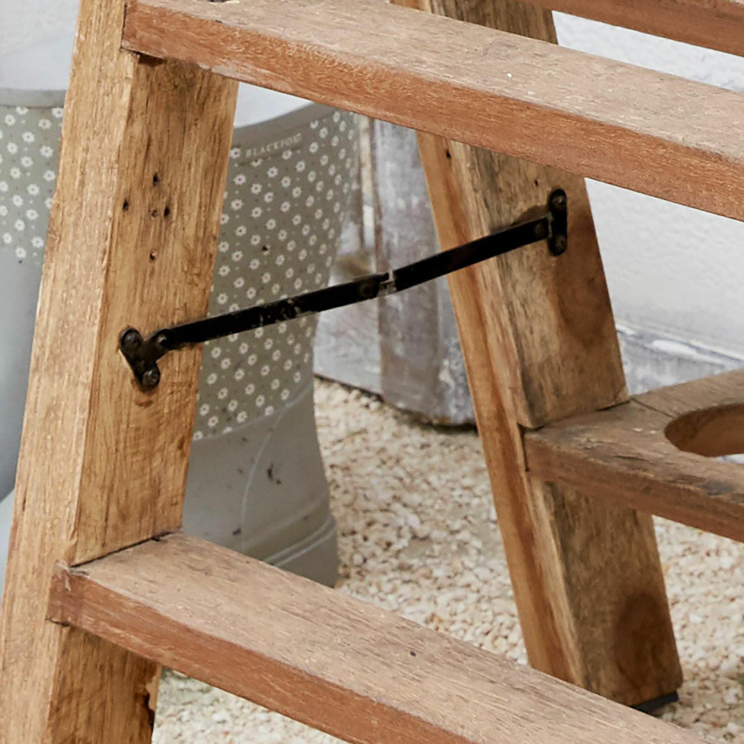 Holzgestell in Naturfarbe mit schwarzem Metallstrebe als Stütze für Gartenmöbel