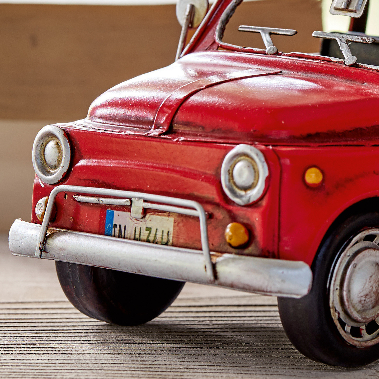 Rotes Metallmodellauto mit Details und Nummernschild auf Holzhintergrund