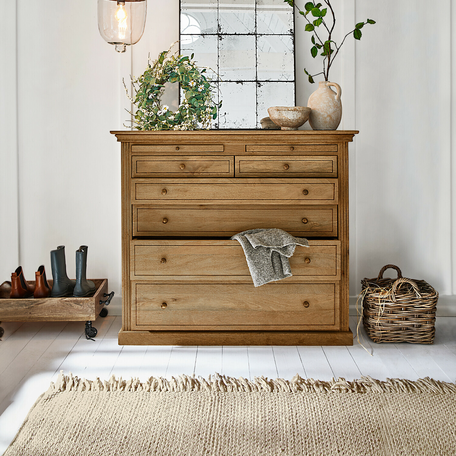 Kommode Espoirin Holzkommode in Naturfarbe mit mehreren Schubladen, Dekorationen und hellem Teppich in hellem Raum