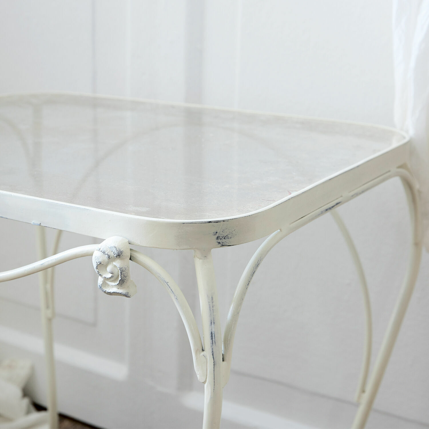 Weißer Metalltisch mit filigranen Verzierungen und leicht patinierter Oberfläche für Innen und Garten