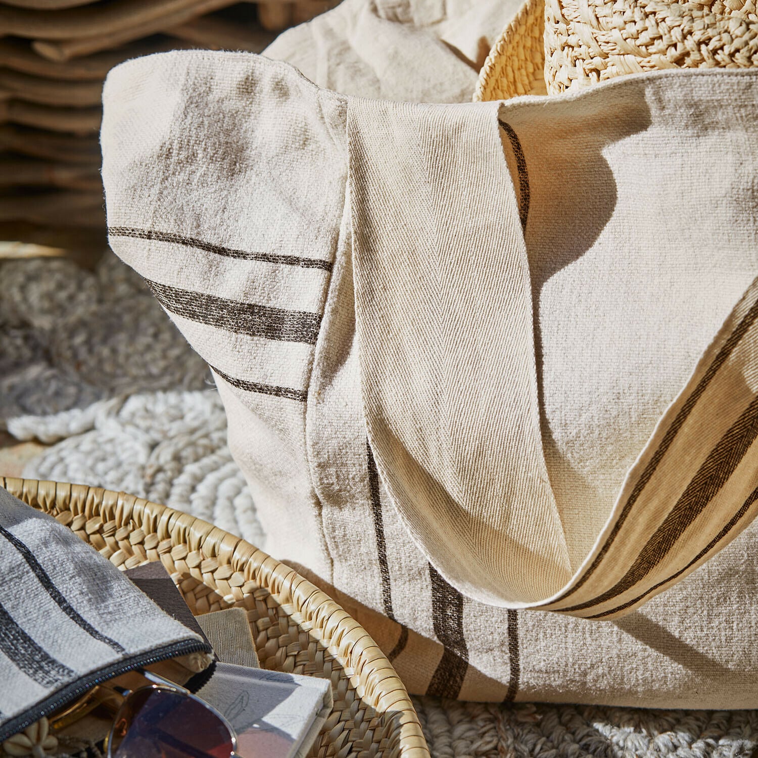 Beige Tasche aus Naturmaterial mit dunklen Streifen, ideal für Strand oder Einkäufe