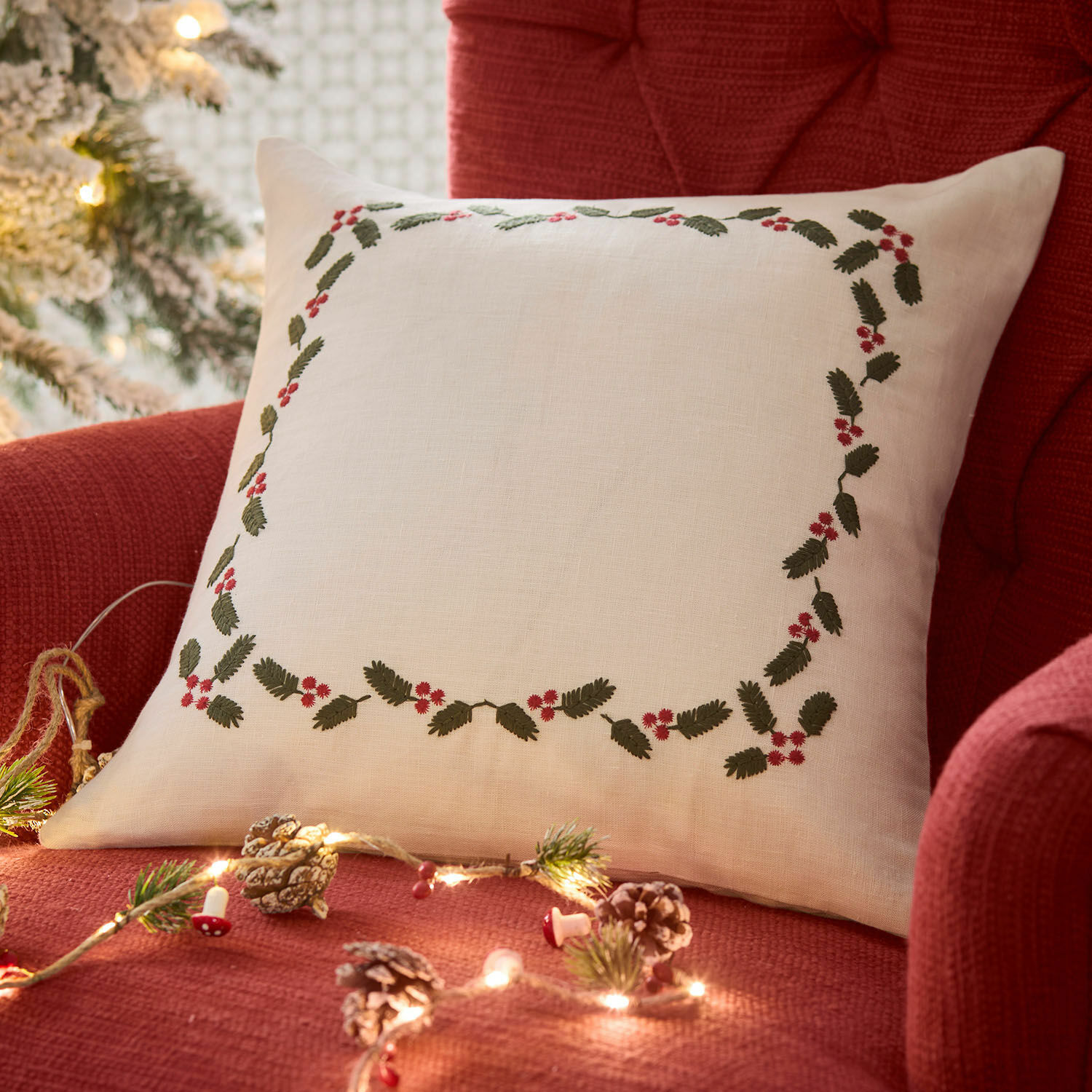 Kissenhülle Lenius Weiße Leinenkissen mit grünen Blättern und roten Beeren auf rotem Sessel, weihnachtliche Dekoration