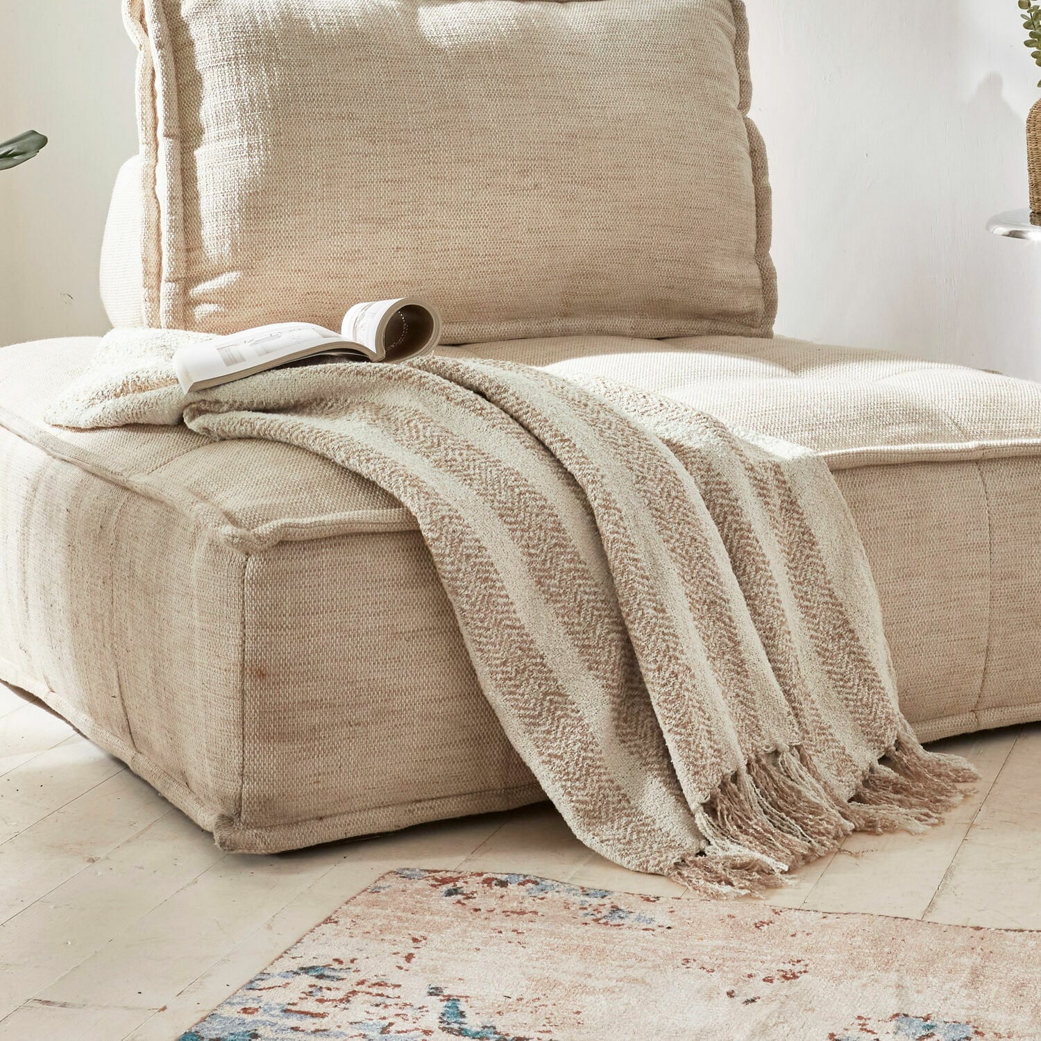 Plaid Aldan Beige weiche Decke mit Fransen auf beigem Stoffsofa in hellem Wohnzimmer