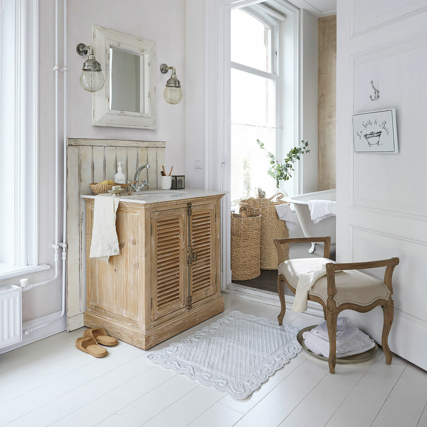 Vintage Badezimmer mit hellem Holzwaschbeckenunterschrank und beige gepolstertem Hocker