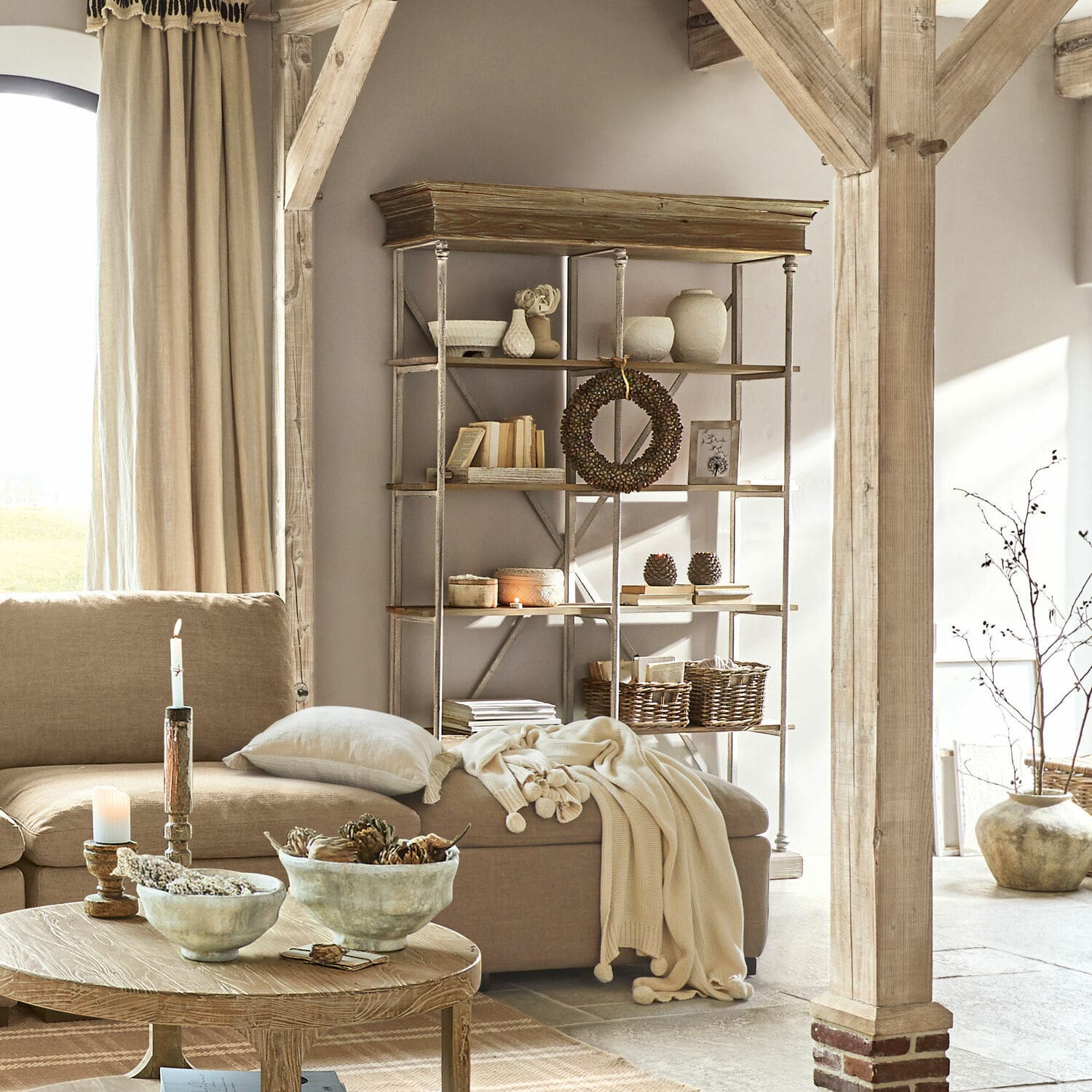 Gemütliches Wohnzimmer mit beigem Sofa, Holztisch und Metall-Holz-Regal als Dekoration