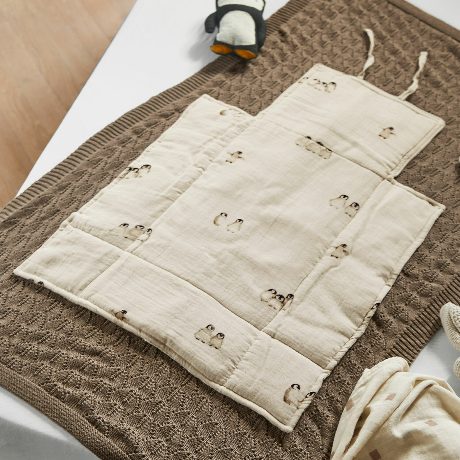Wickelunterlage Jocienne Beige Baumwoll-Kinderkrabbeldecke mit Pinguin-Motiv auf braunem Strickdecke, Babyzubehör