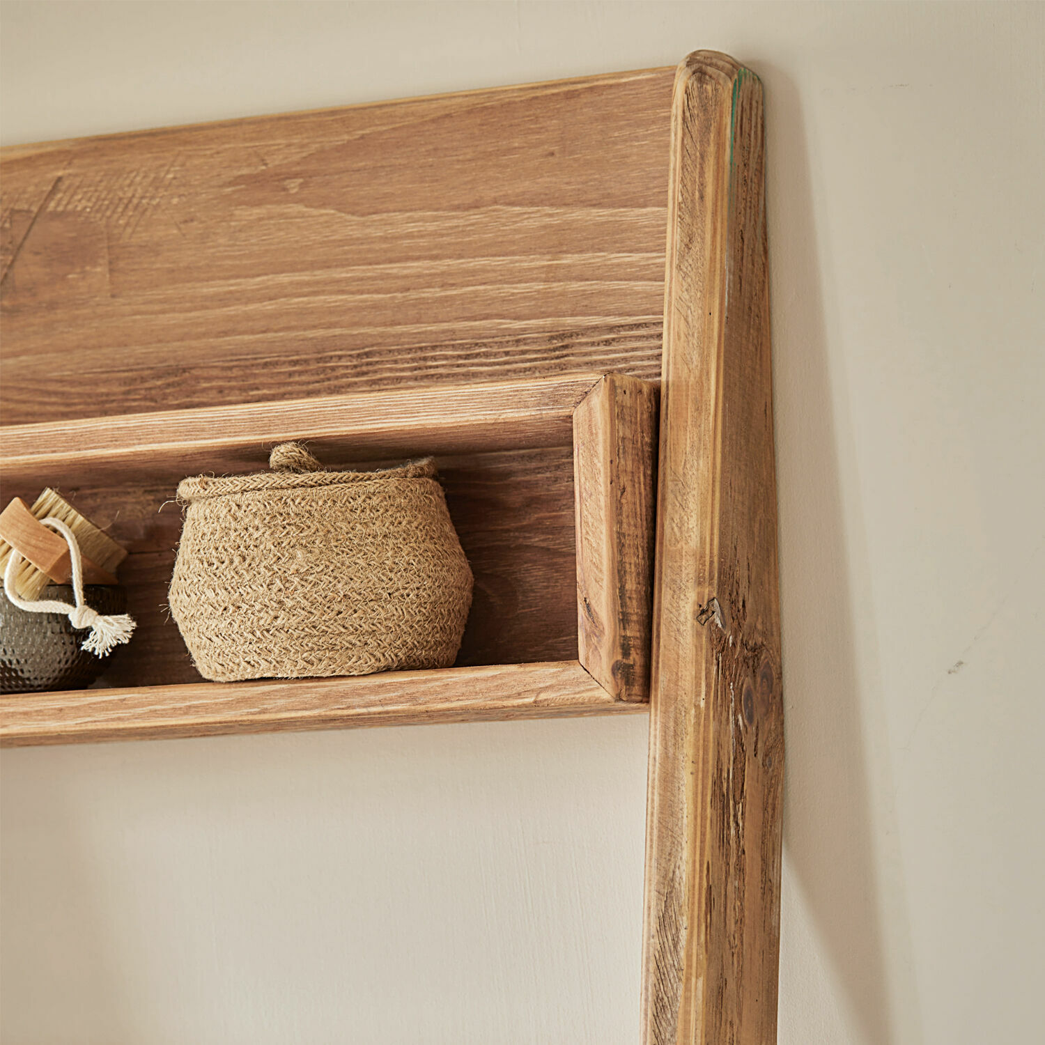 Wandregal aus Naturholz mit geflochtenem Korb und Bürste als rustikale Wohnaccessoires