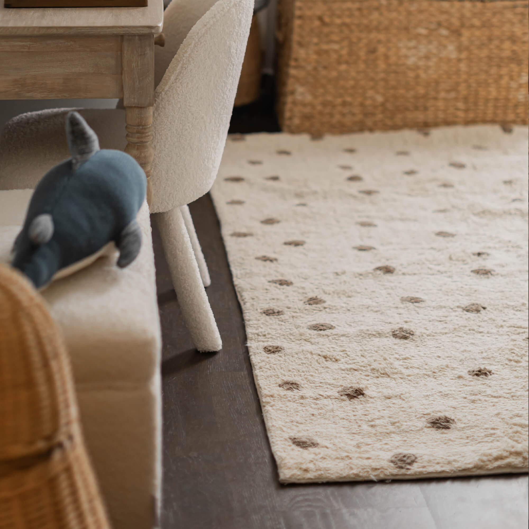 Beiger Teppich aus weichem Material mit braunen Punkten auf dunklem Boden im Wohnzimmer