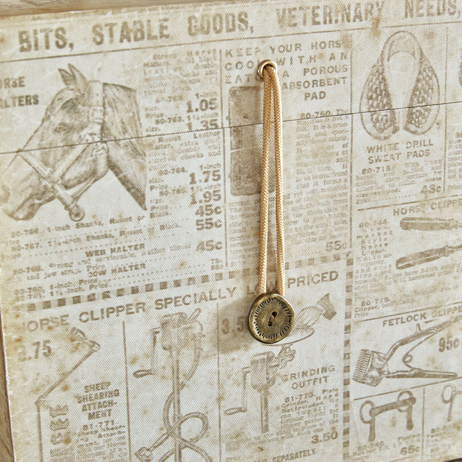 Beiger Stoff mit Vintage-Druck und Kordel mit Metallknopf als Wohnaccessoire
