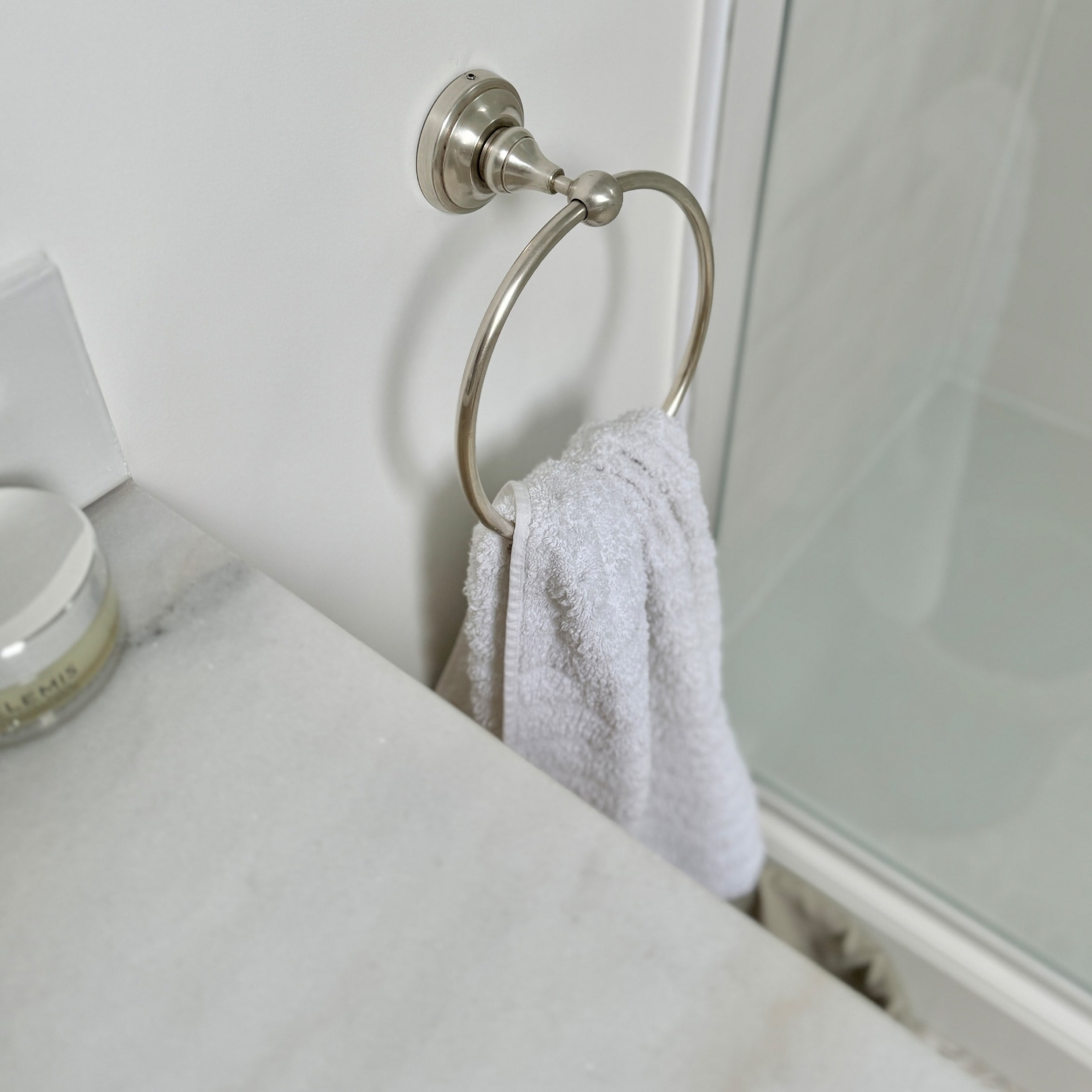 Metall-Handtuchhalter mit weißem Handtuch und Marmorarbeitsplatte im Badezimmer