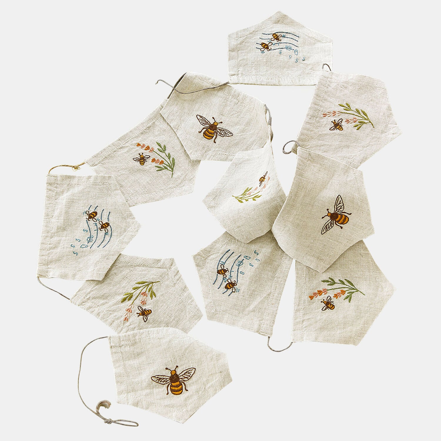 Leinen-Gesichtsmasken in hellem Naturton mit bestickten Bienen und Blumenmotiven, dekoratives Set