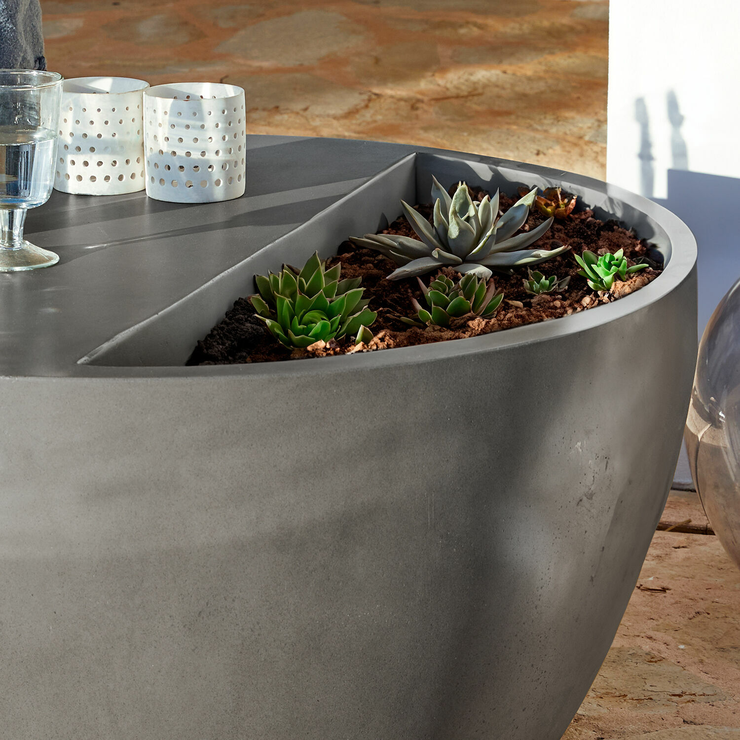 Grauer Betontopf mit grünen Sukkulenten auf Terrasse, moderne Gartendekoration
