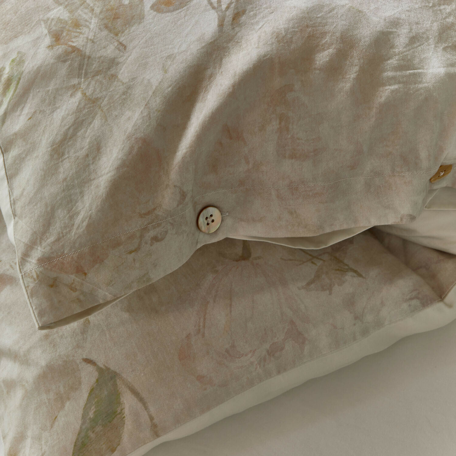 Leinen-Kissenbezug in Beige mit zartem Blumenmuster und dekorativen Knöpfen