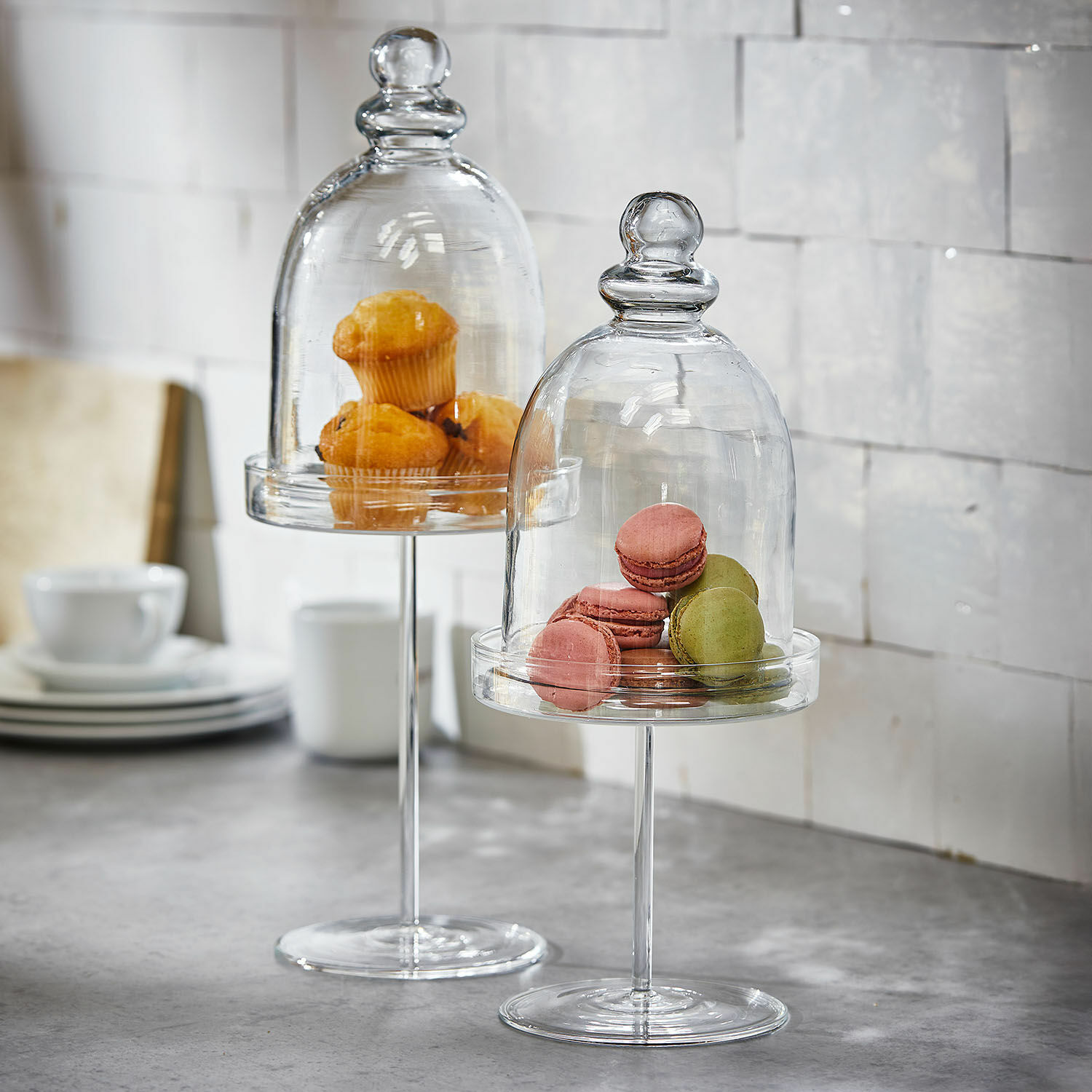 Glasglocke 2er Set Hibous Glasständer mit transparenten Glocken, die Muffins und Macarons auf einer Küchenarbeitsplatte präsentieren